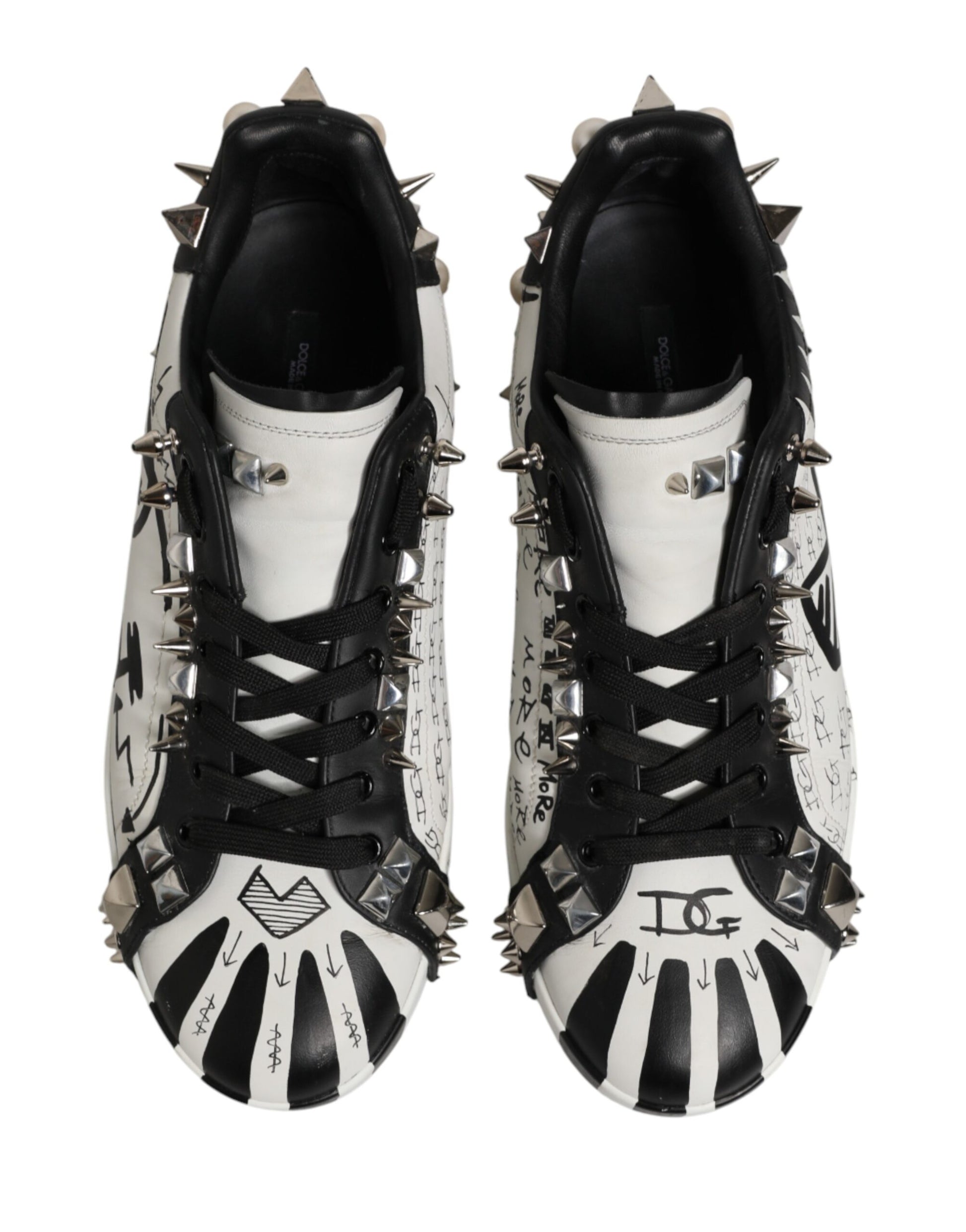 Pair of black and white sneakers with spikes on the sides