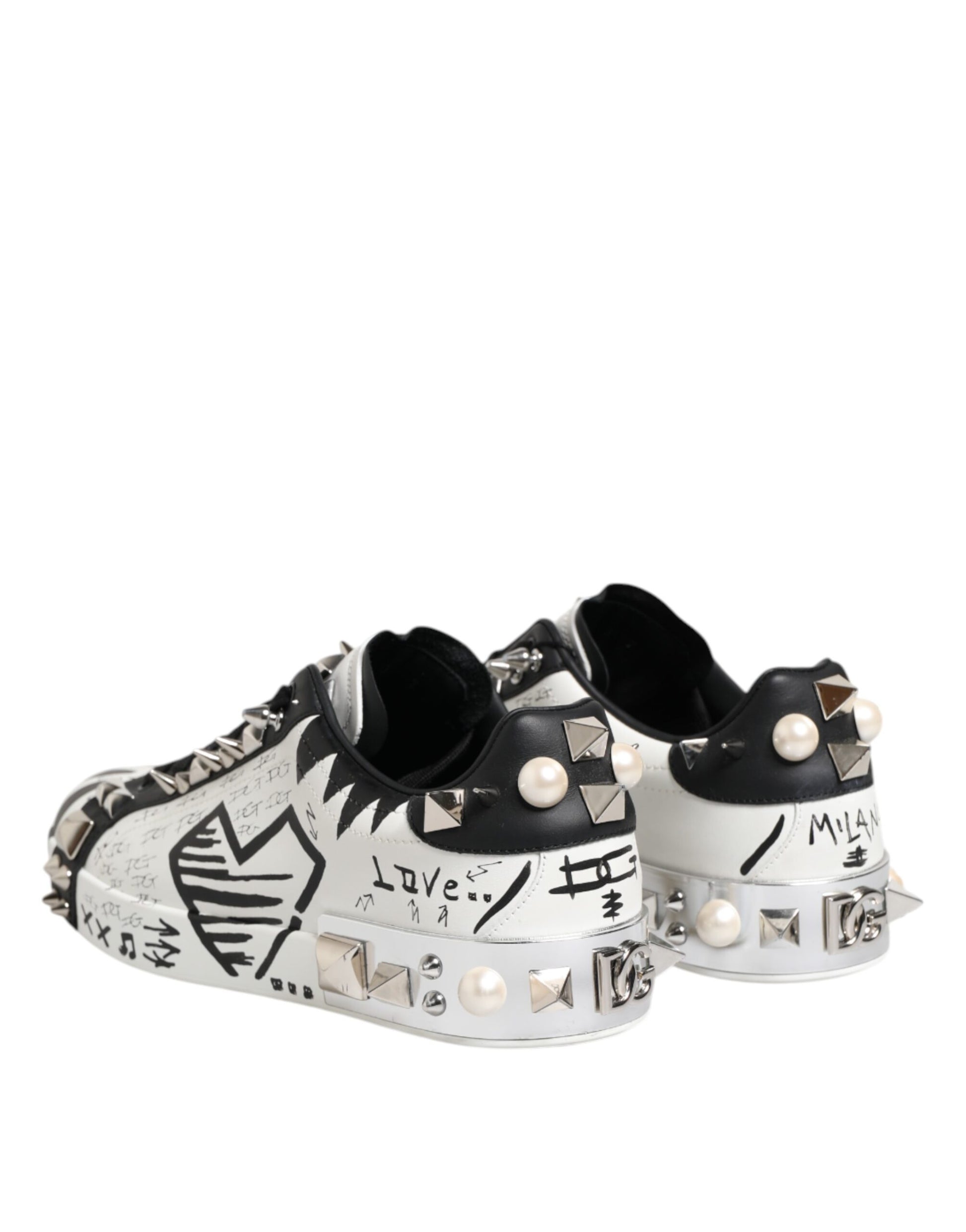 A pair of black and white studded sneakers with a low top, featuring a design that includes pearls and spikes