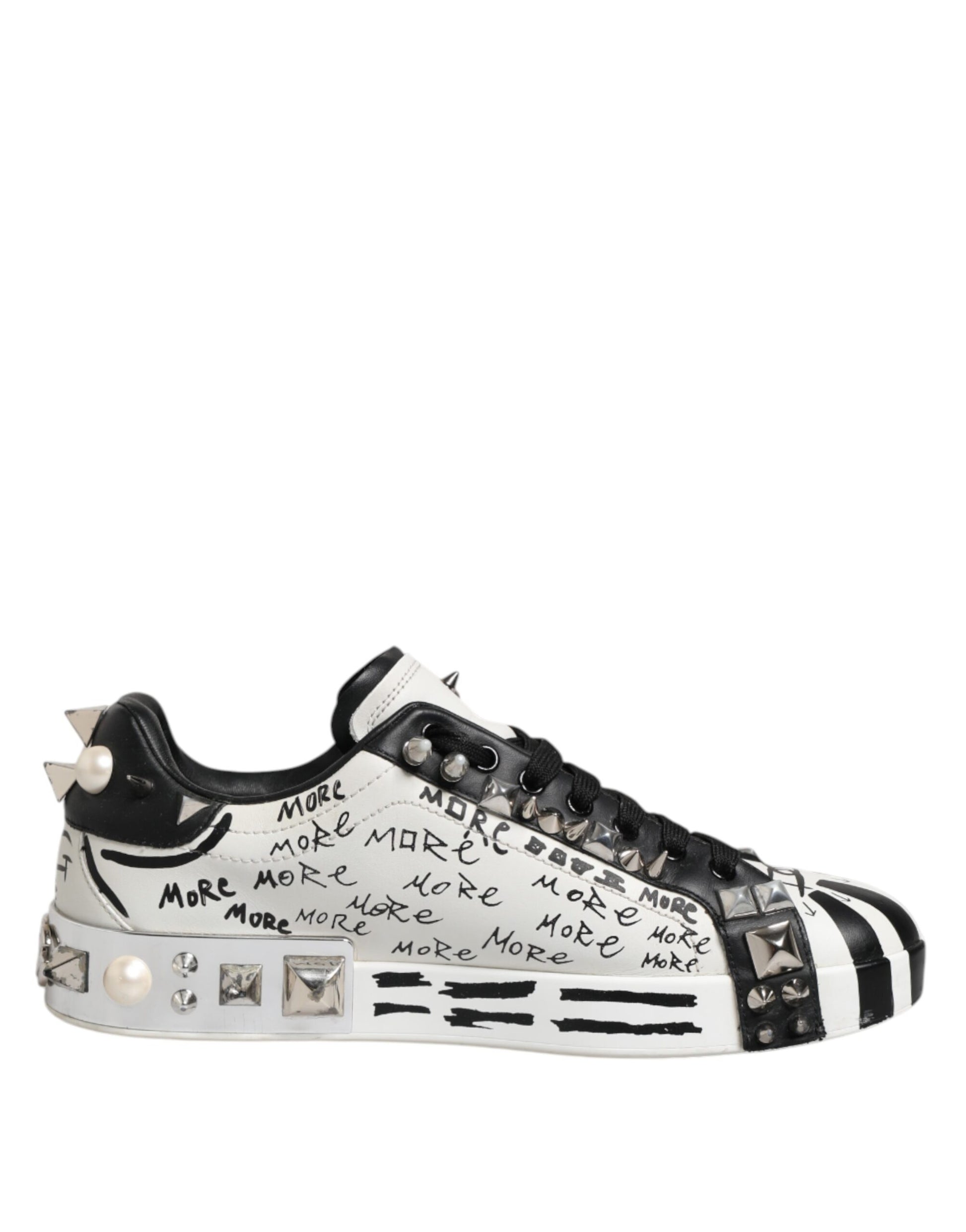 A pair of black and white studded low top sneakers with a bold statement on the side