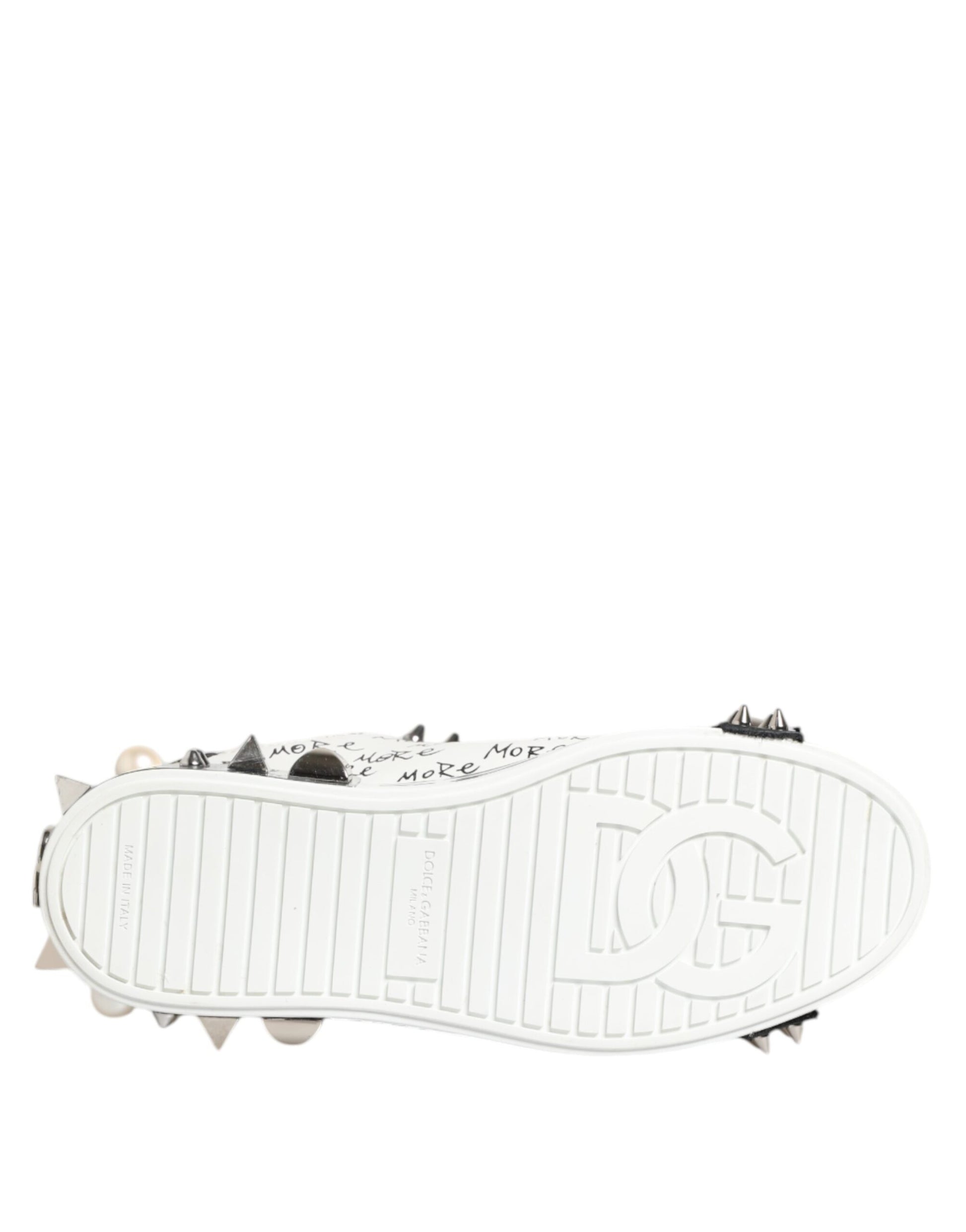 A pair of black and white sneakers with studs, featuring a low top design