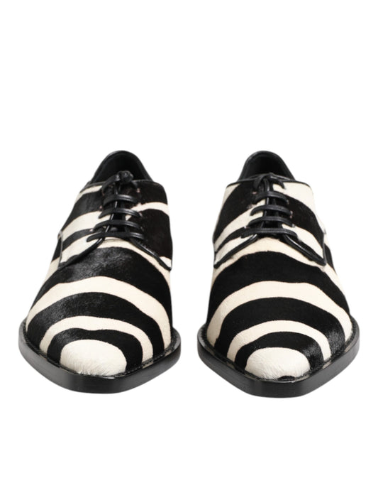 A pair of black and white zebra print shoes with fur trim