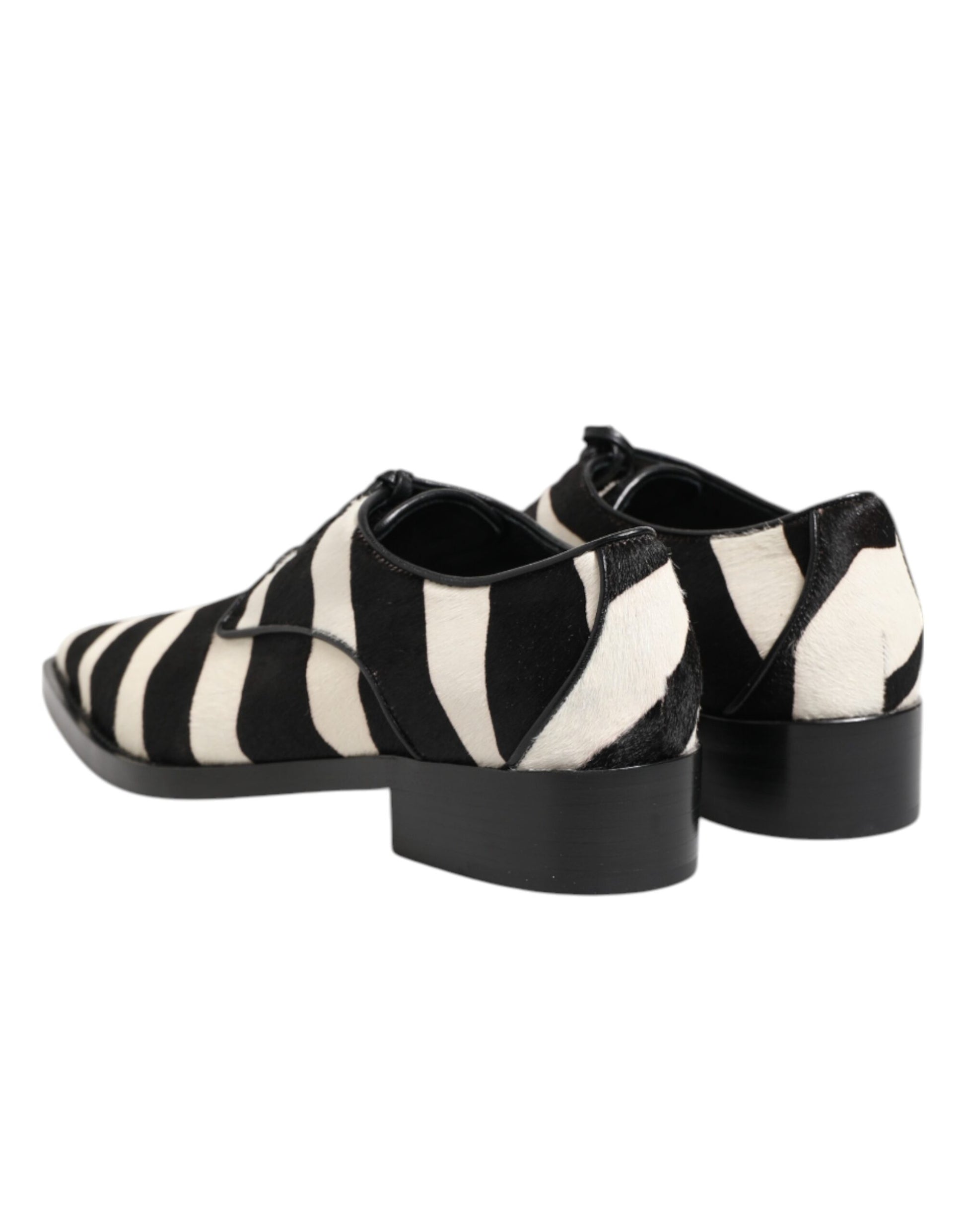 A pair of black and white zebra print shoes with a fur trim