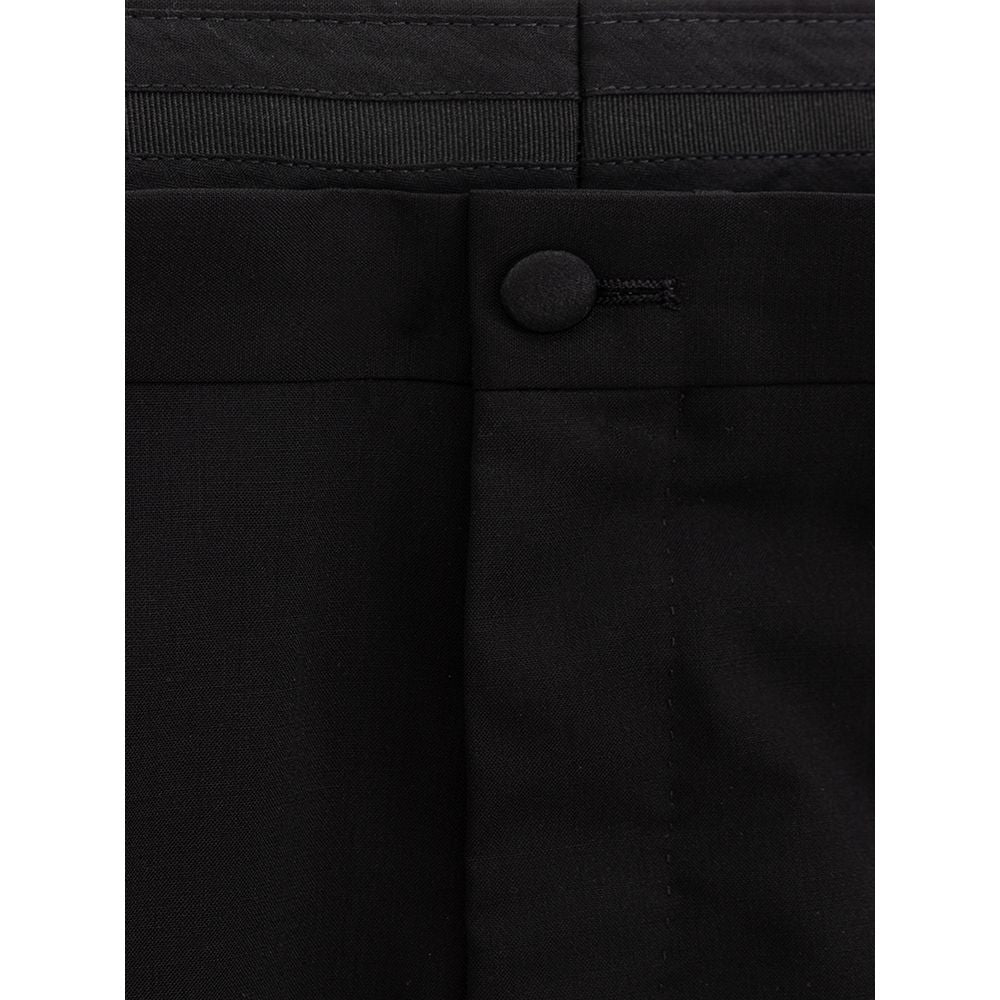 A pair of black wool dress pants with a buttoned front pocket and a zipper fly