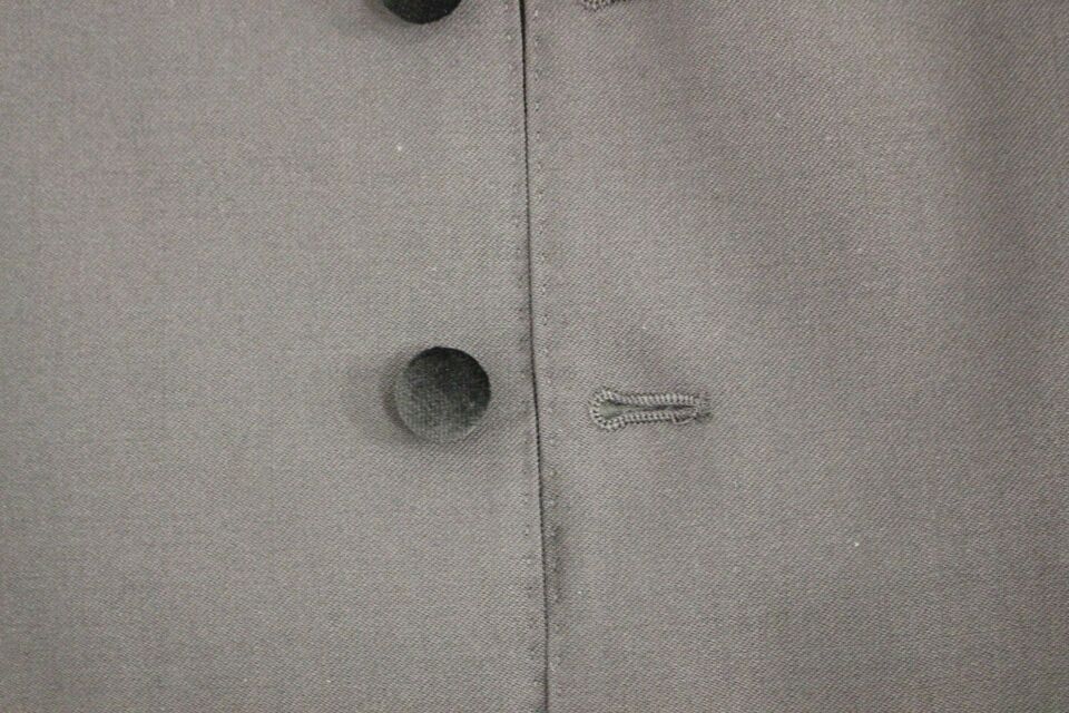 A black wool vest with a buttonhole and button closure