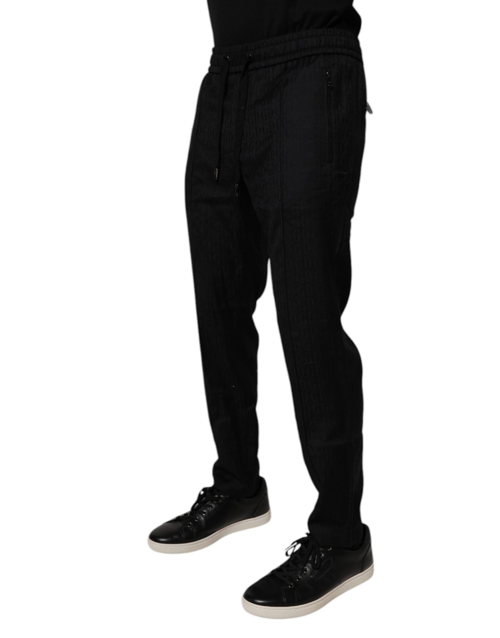 Man wearing black pants and shoes standing against white background