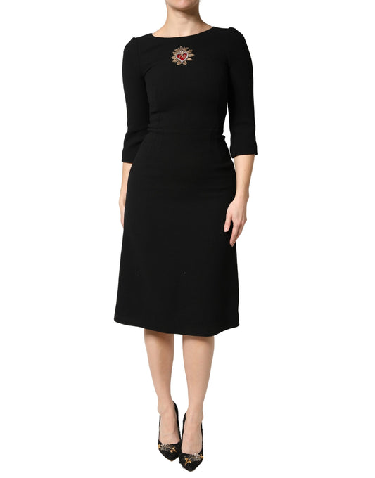A black midi dress with a sacred heart patch on the chest, designed by Dolce & Gabbana
