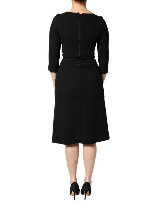 A black midi dress with a sacred heart patch on the front, designed by Dolce & Gabbana