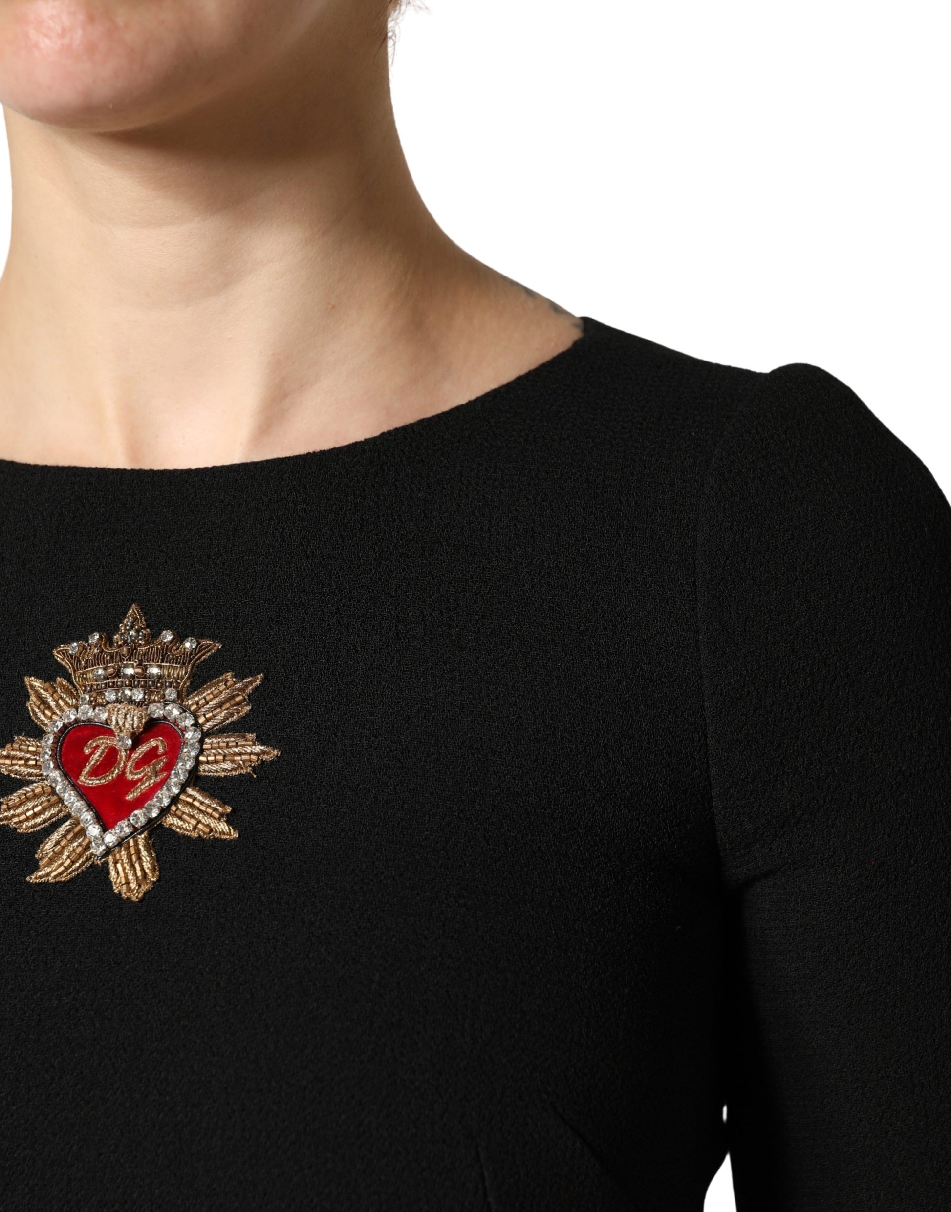A black wool midi dress with a heart-shaped patch on the chest