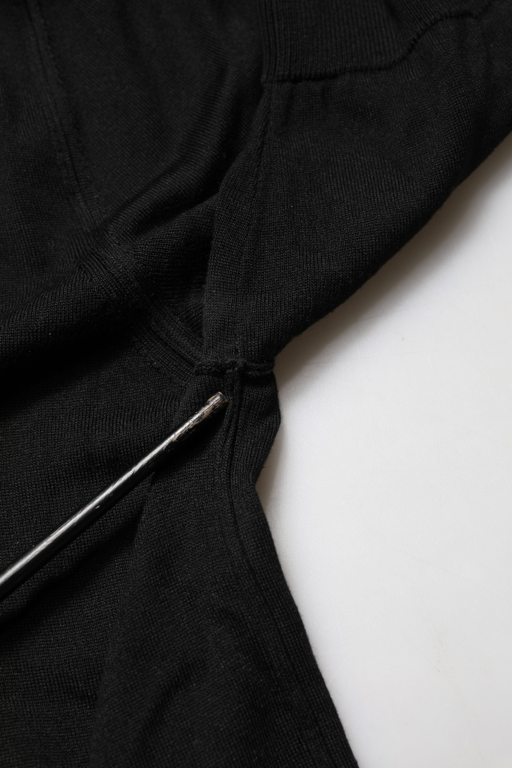 Black jacket with zipper on white surface