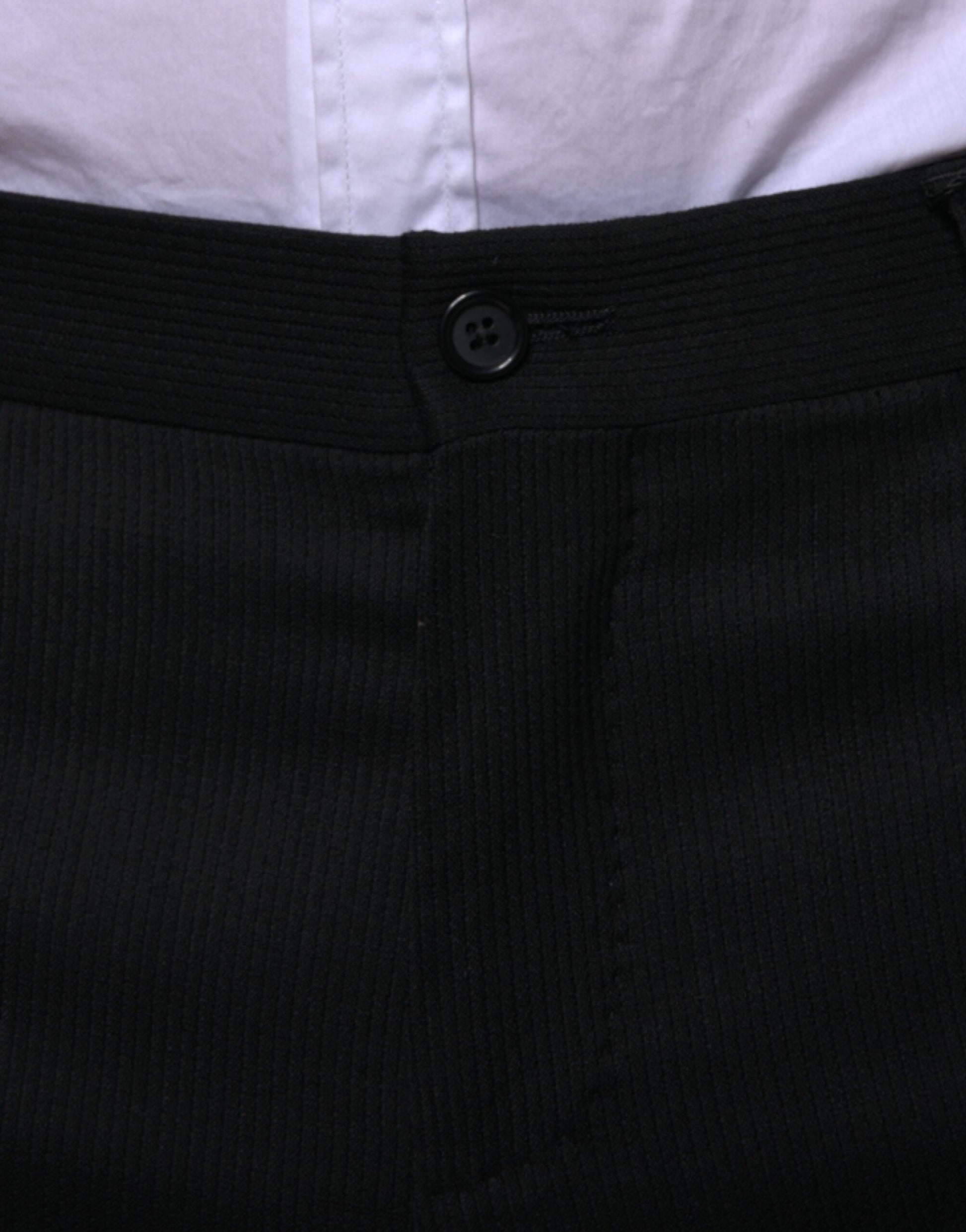 A pair of black wool skinny formal dress pants with a buttoned waistband