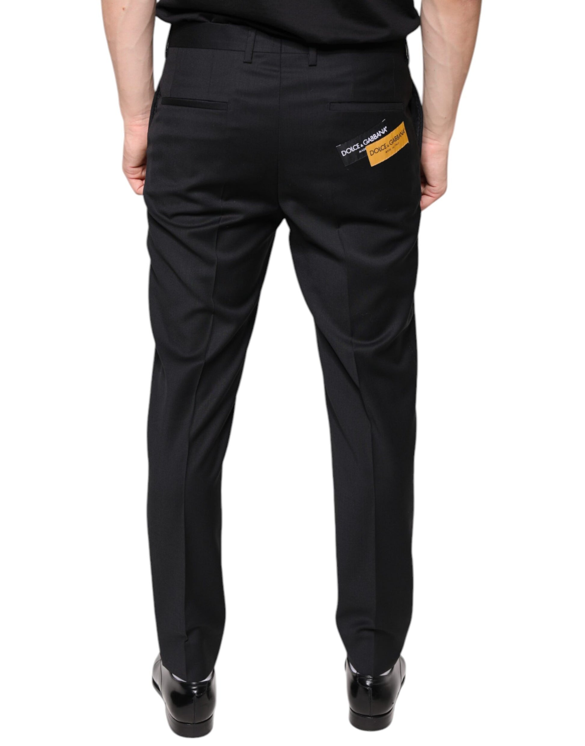 A pair of black wool skinny dress pants with a yellow label on the back