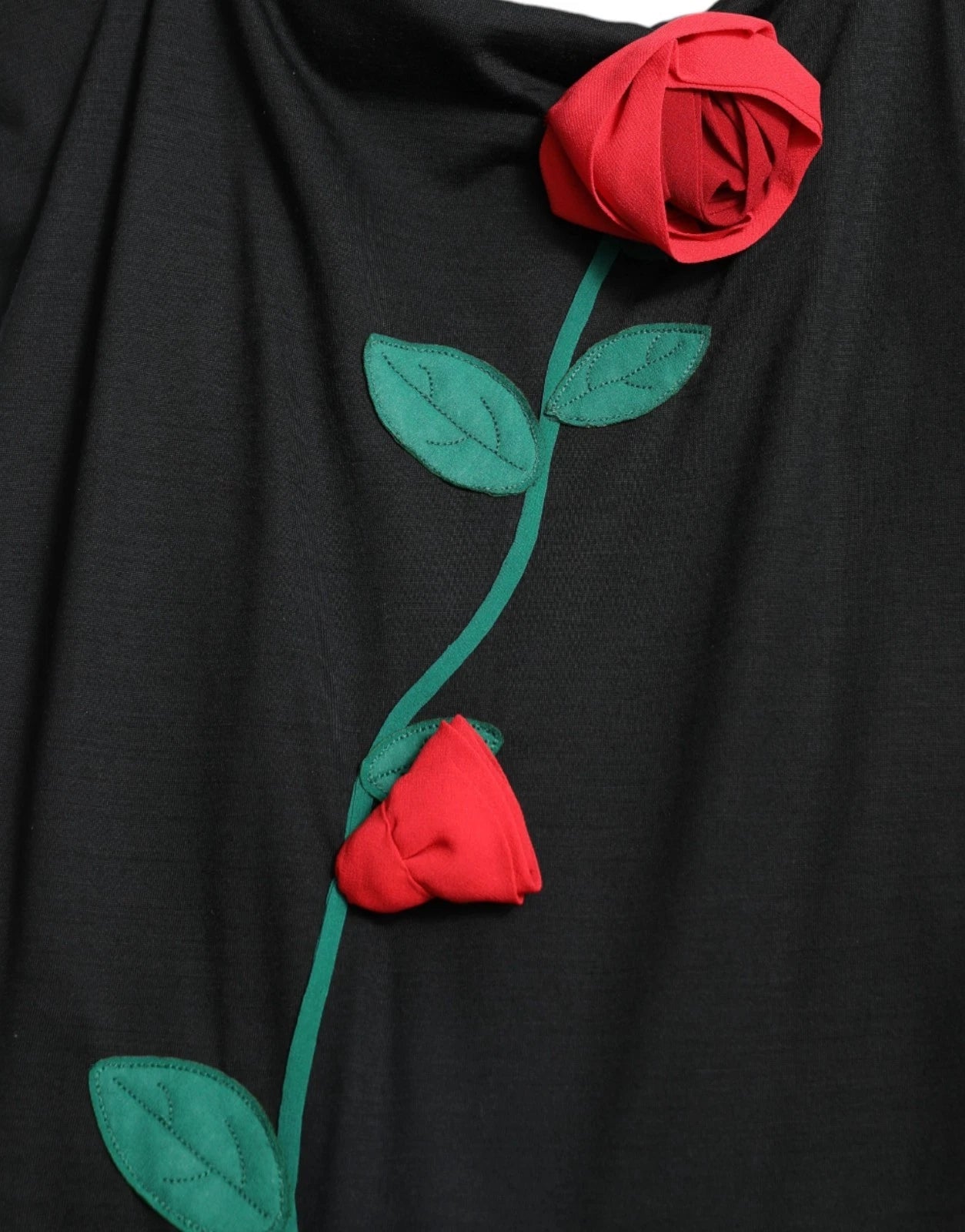 A black wool sleeveless dress with a rose applique on the side