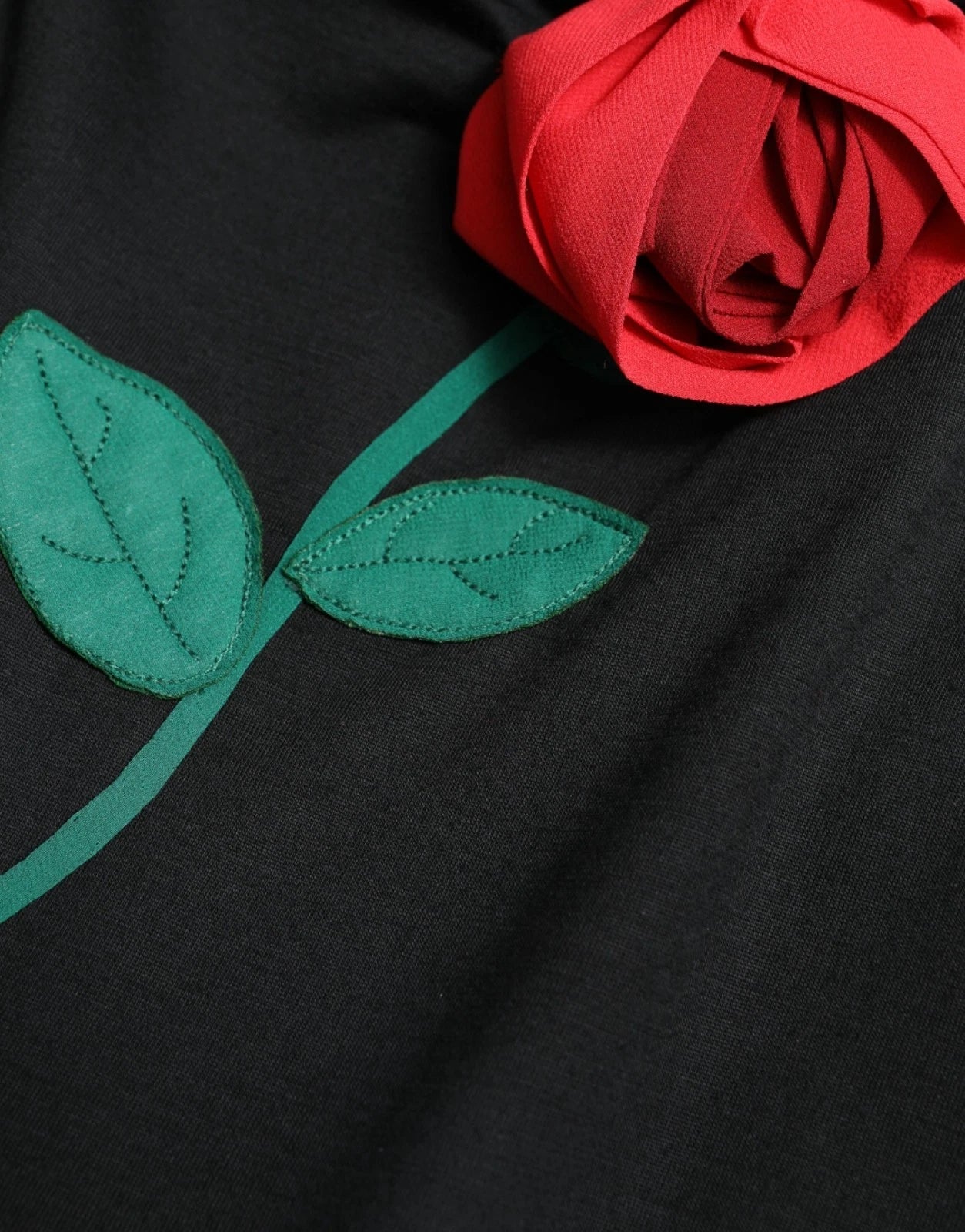 A black wool sleeveless dress with a rose applique on the front