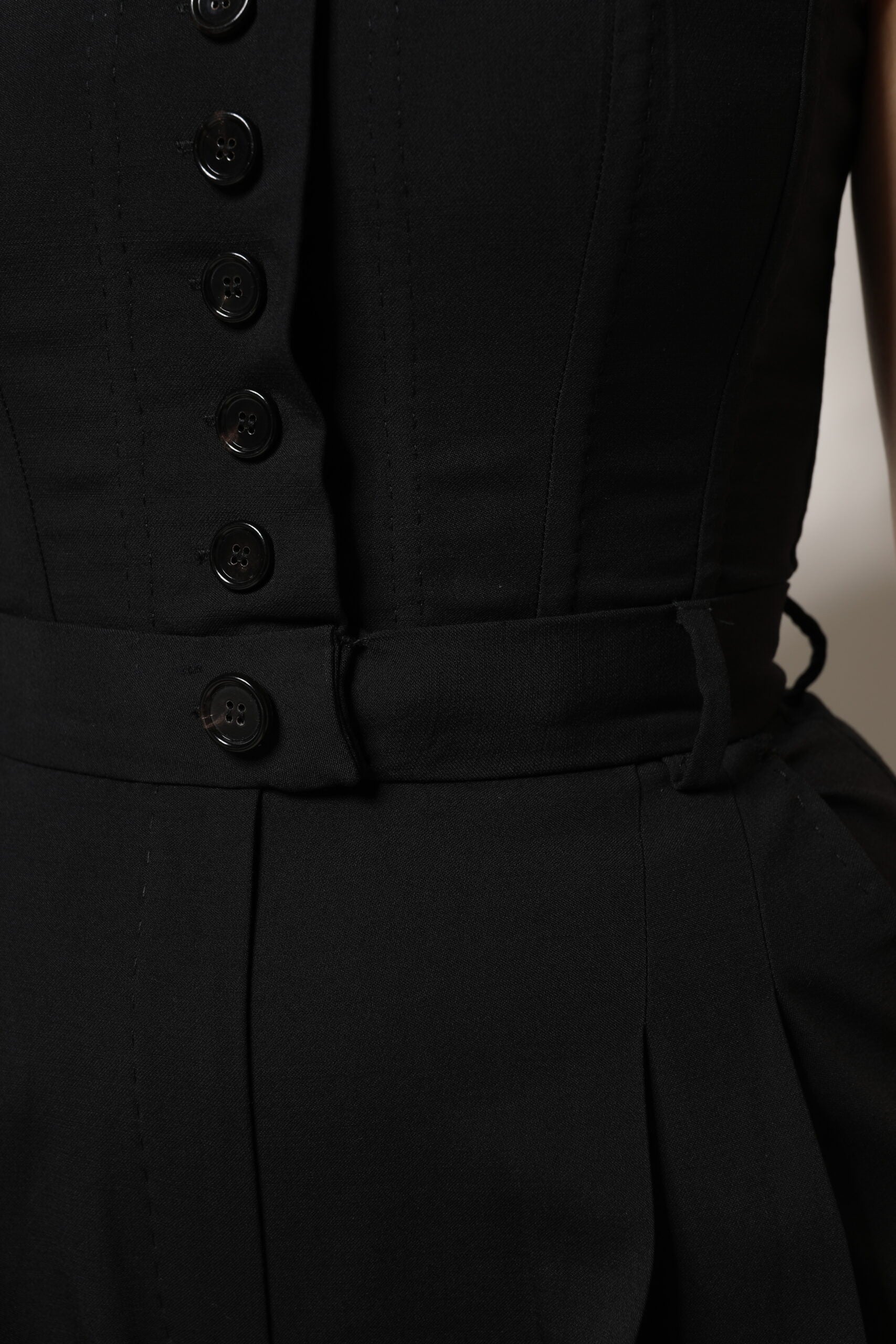 A black wool strapless romper jumpsuit dress with buttons and belt