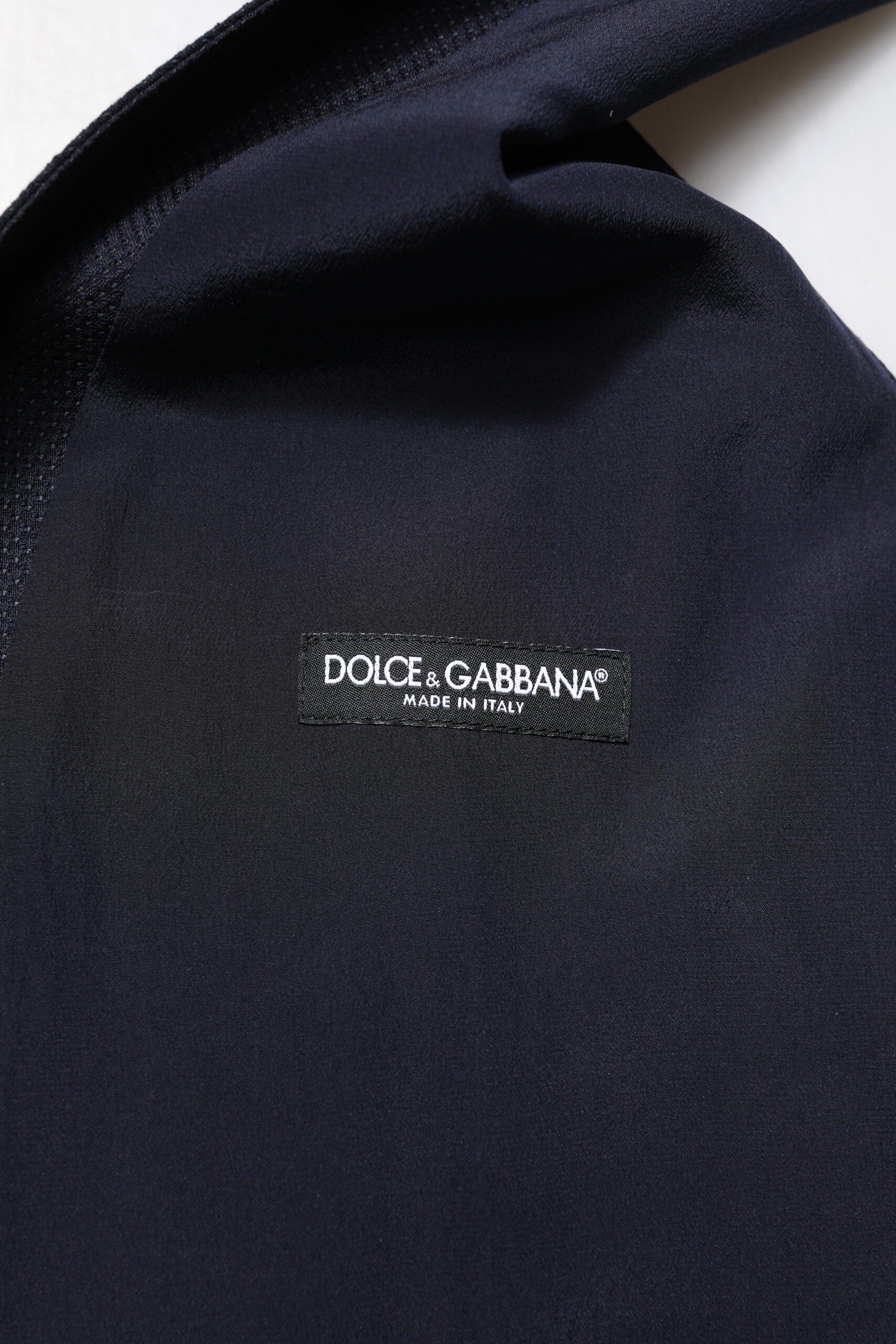 A black wool waistcoat with a brand logo on the front