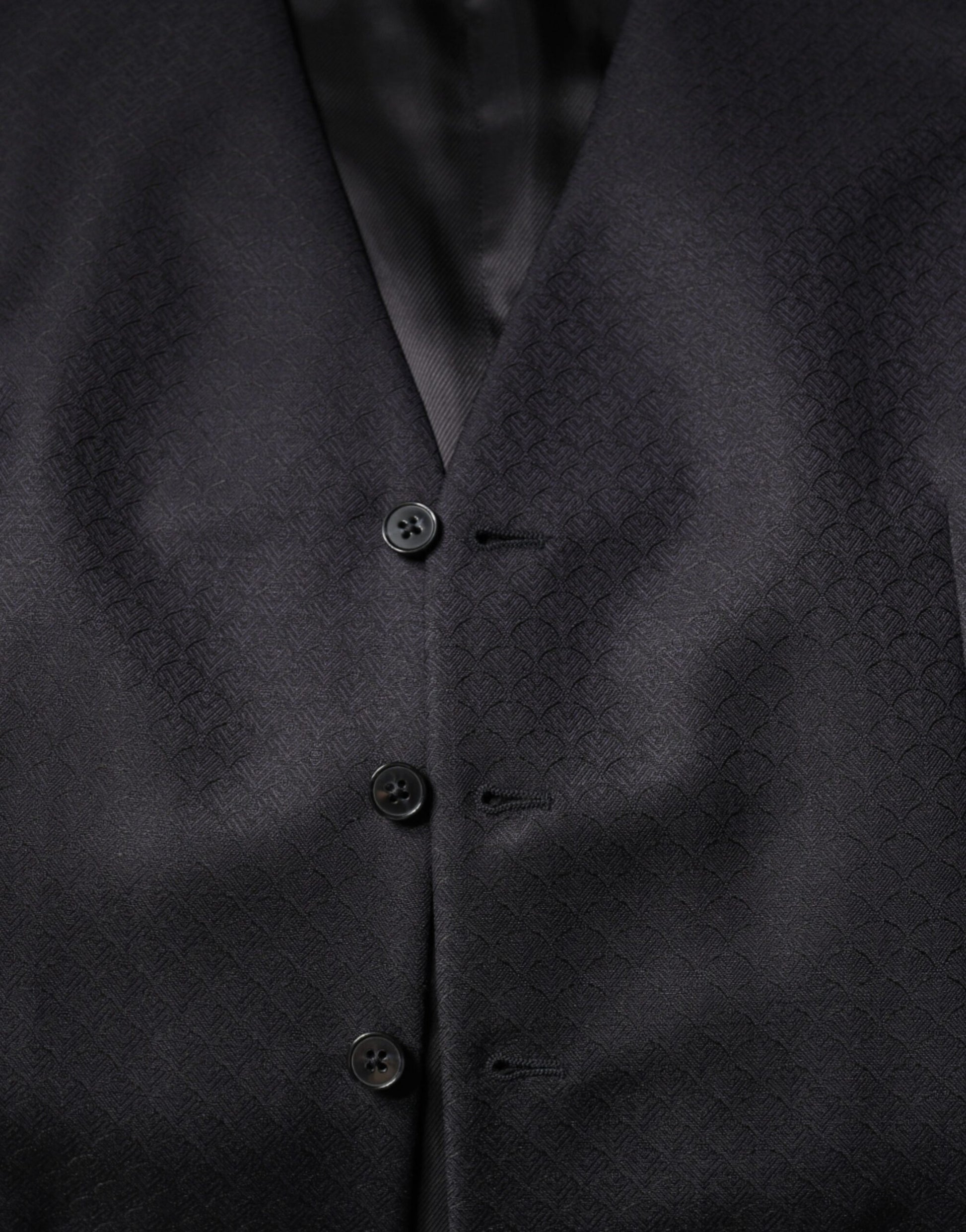 A black wool vest with three buttons and a lapel, part of a formal dress suit