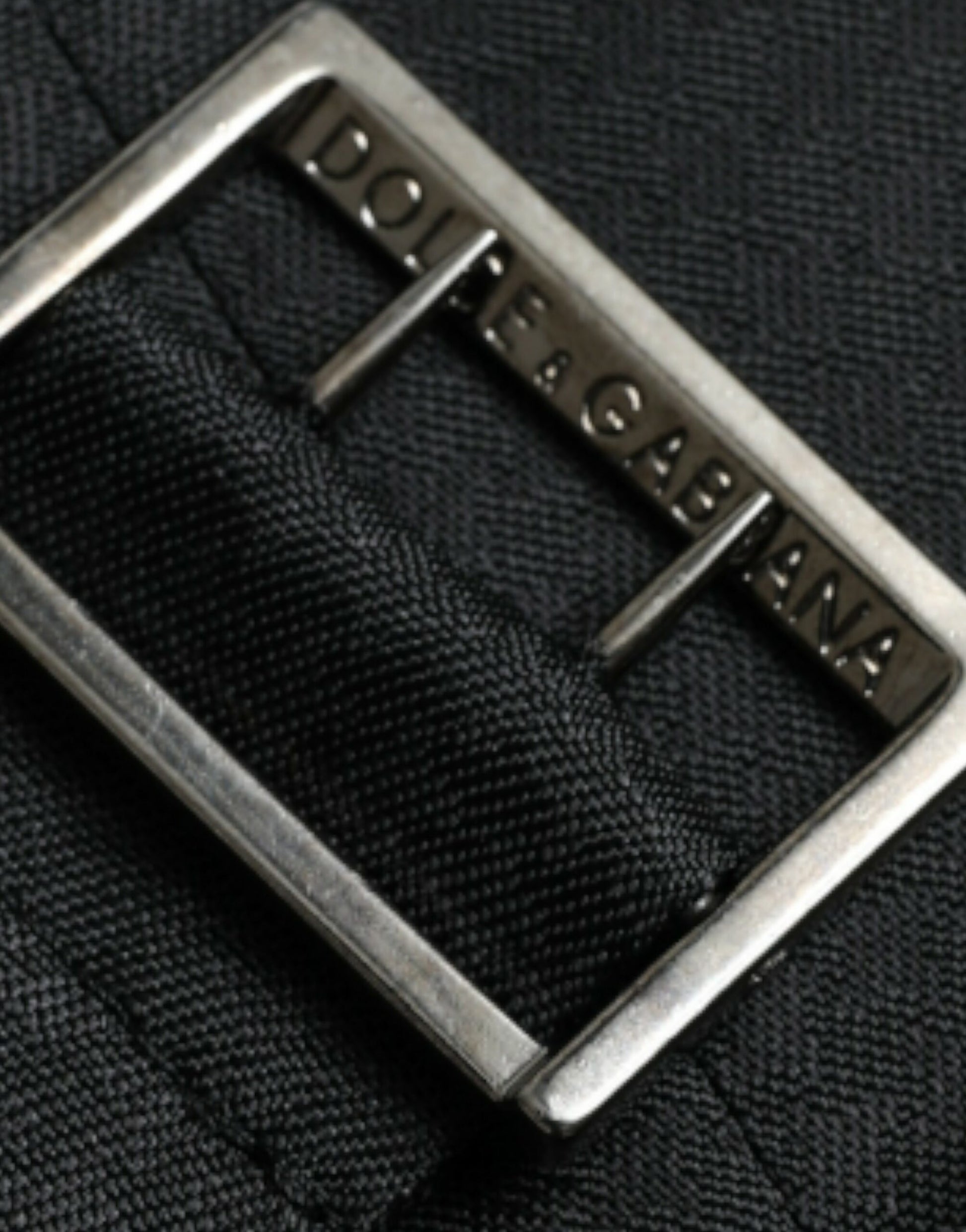 Silver buckle on black waistcoat