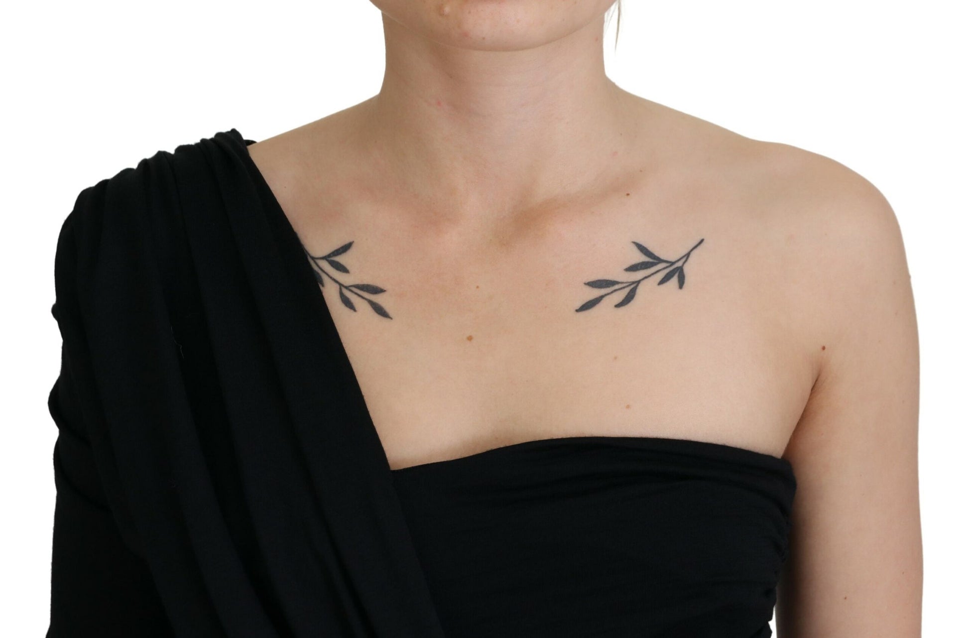 Woman wearing black dress with shoulder cutout revealing tattoo on upper arm