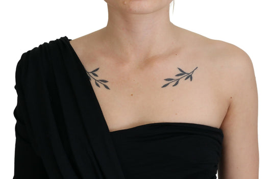 Woman wearing black dress with shoulder cutout revealing tattoo on upper arm