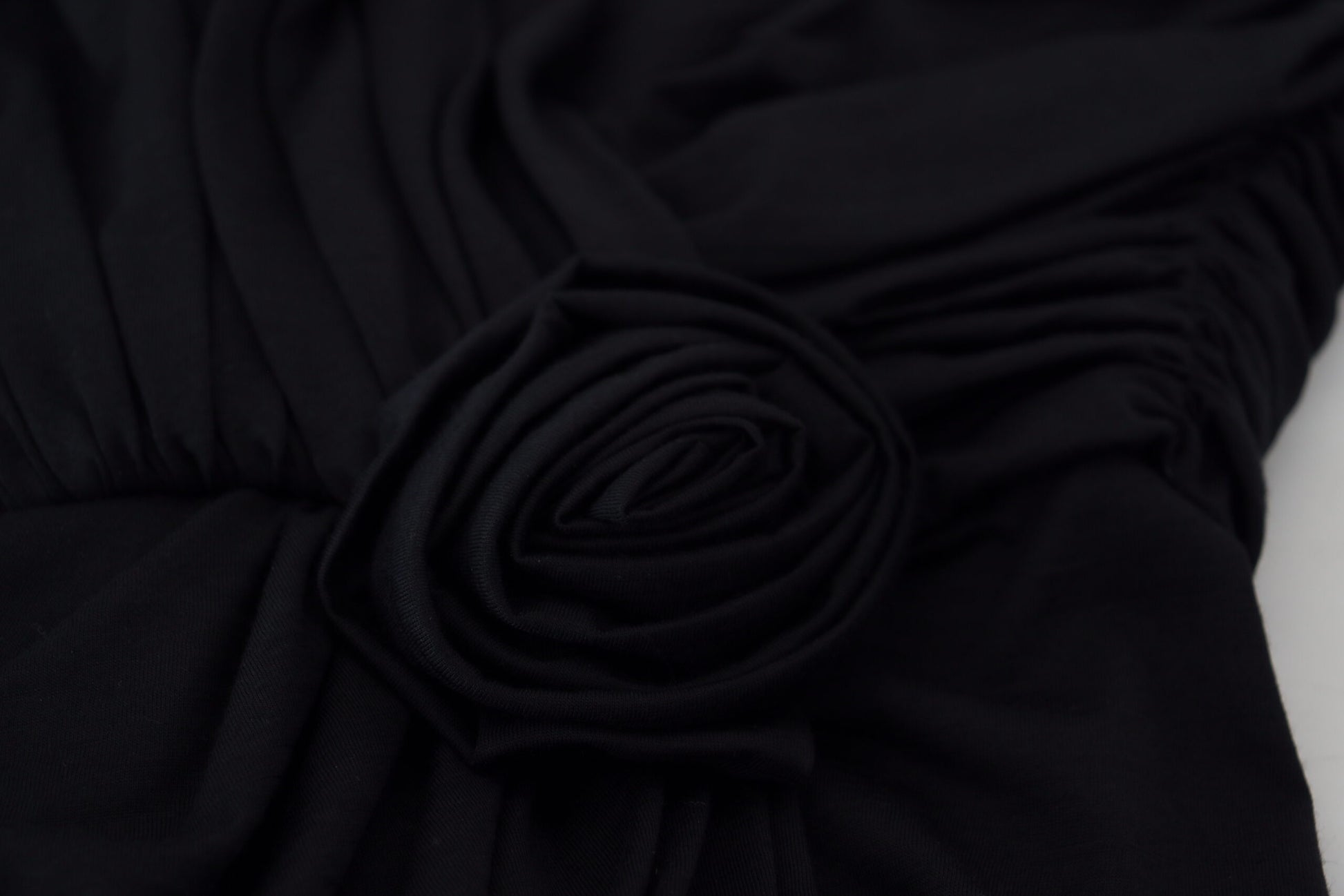 Black fabric with ruffled edges and a bow detail