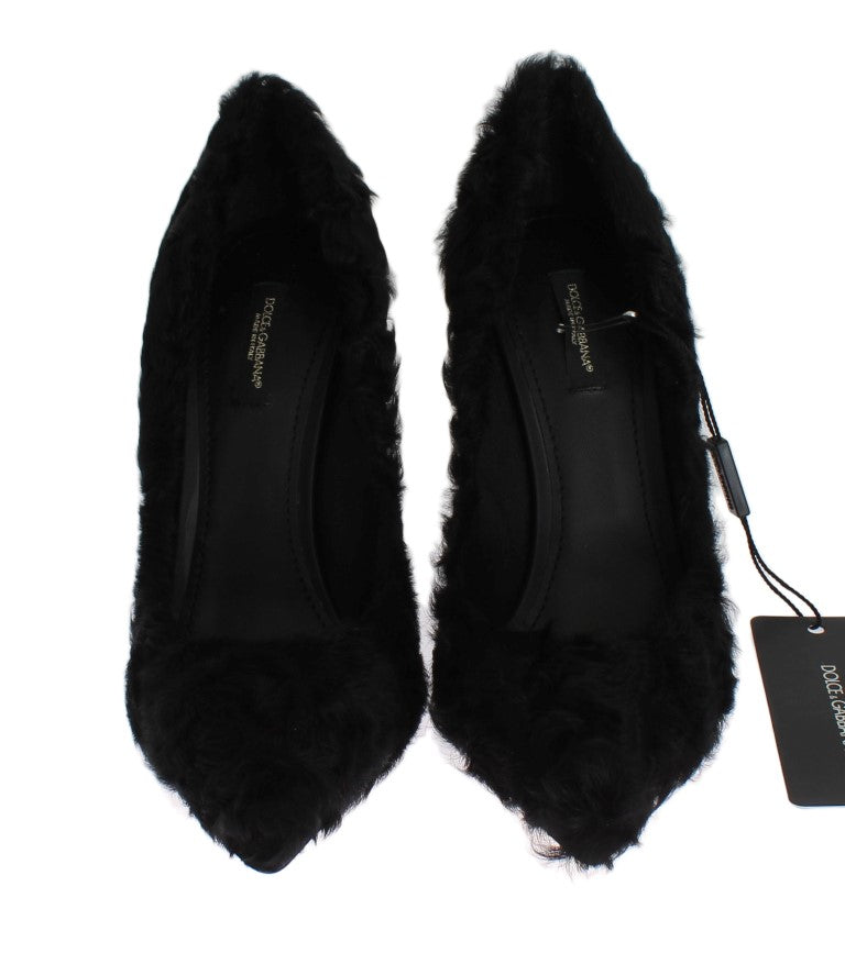Pair of black furry women's shoes with a bow on top