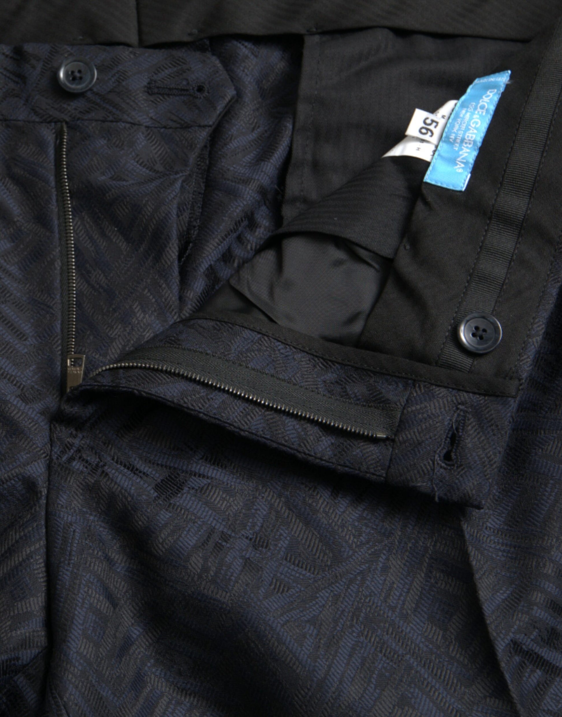 A pair of men's dress pants with a blue brocade wool pattern. They are designed by Dolce & Gabbana and featur