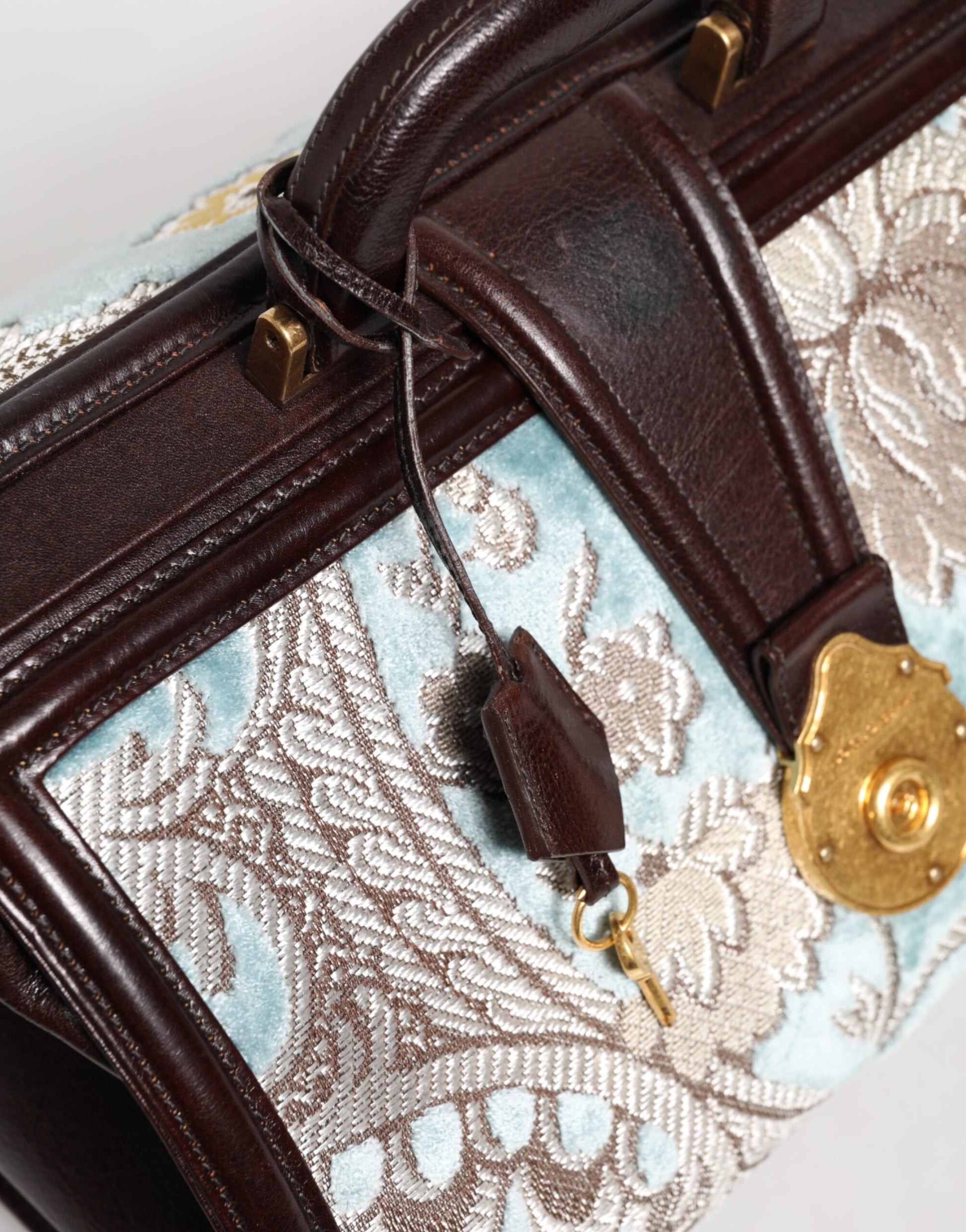 Brown leather suitcase with blue floral pattern on side
