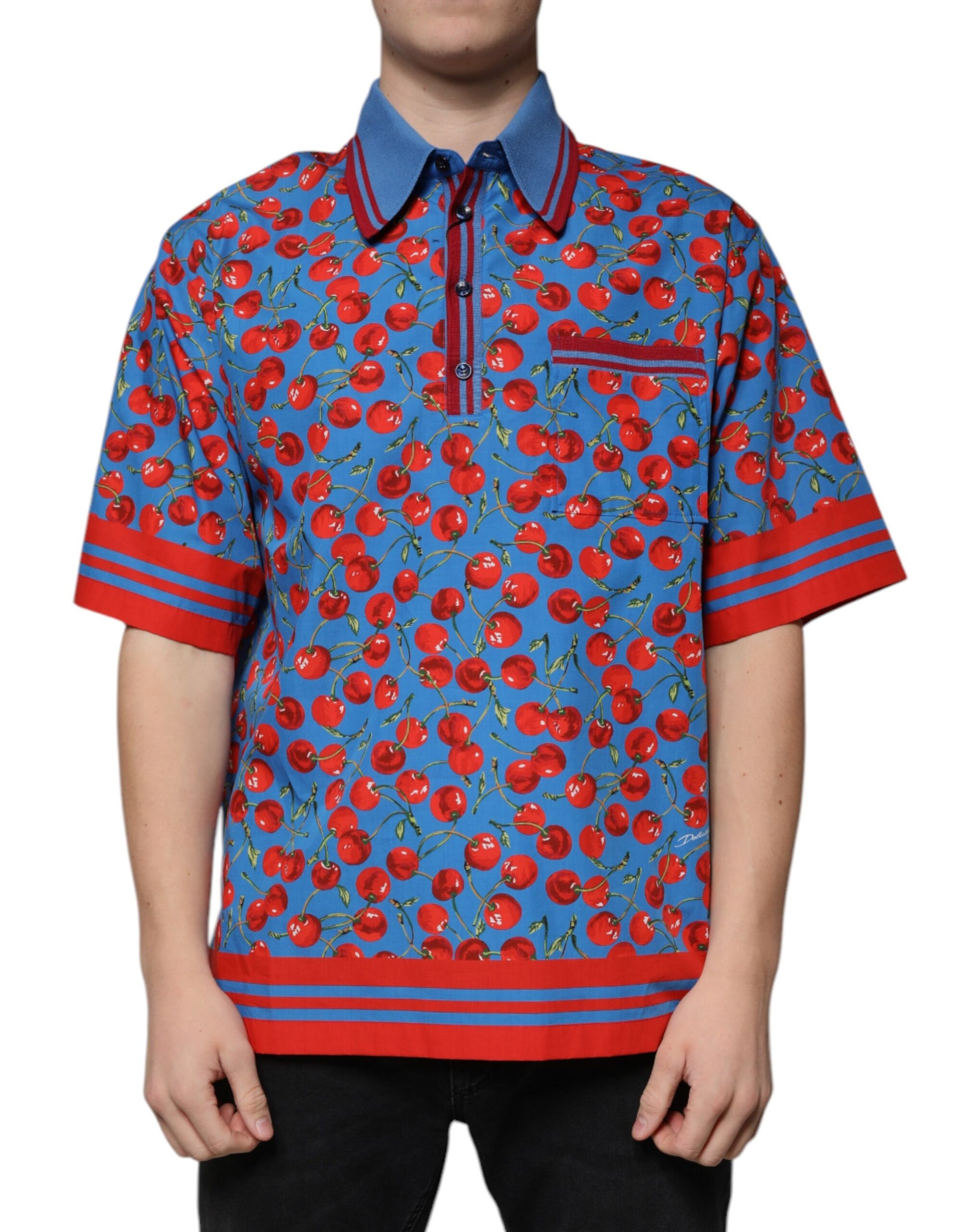 The shirt is colorful with a pattern of red cherries on blue background