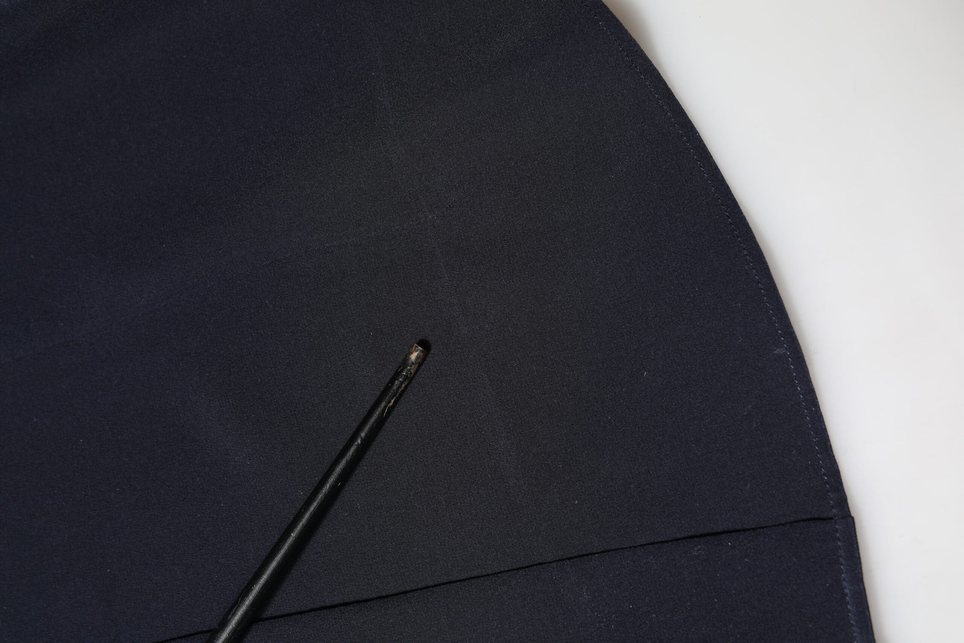 A black dress shirt with a collar, long sleeves and a button on the front