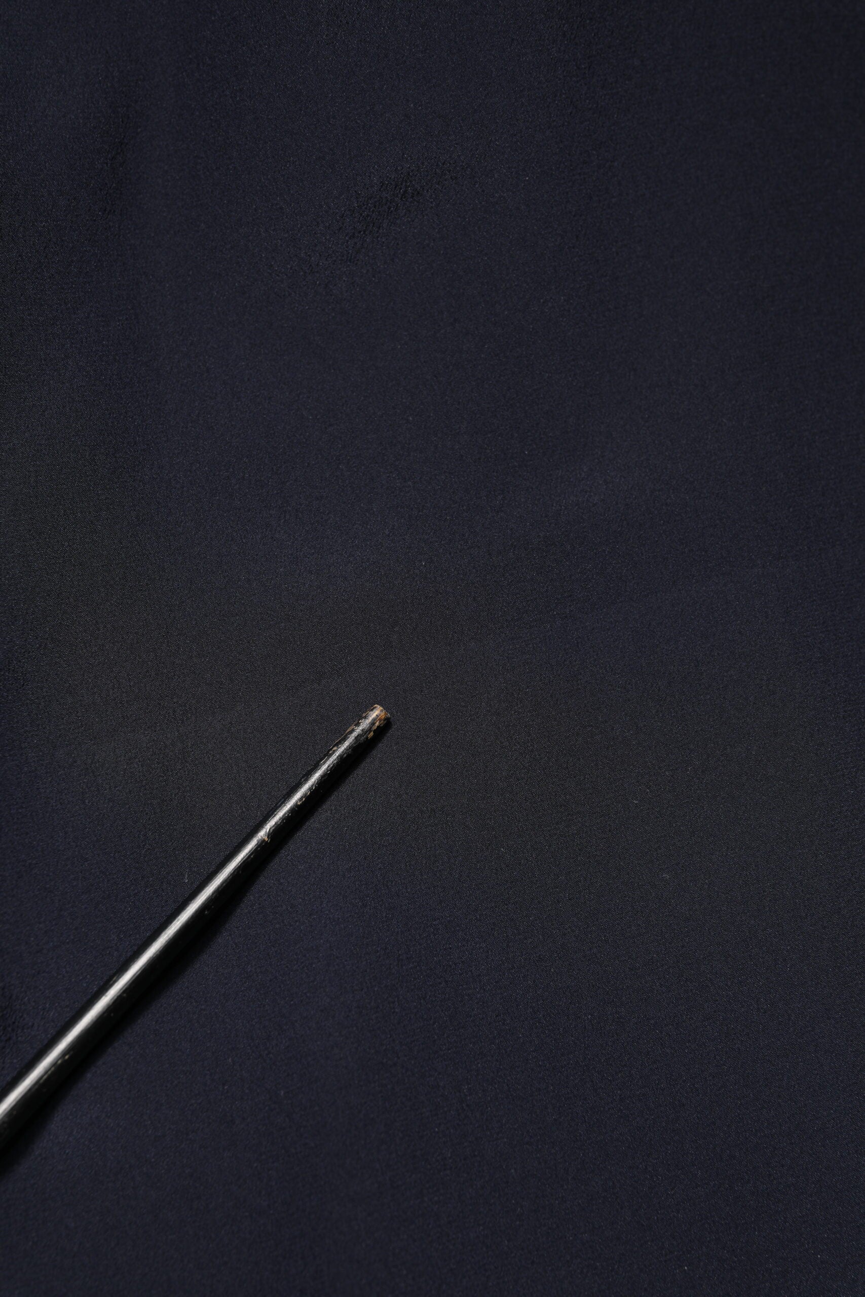 A black dress shirt with a blue collar and long sleeves