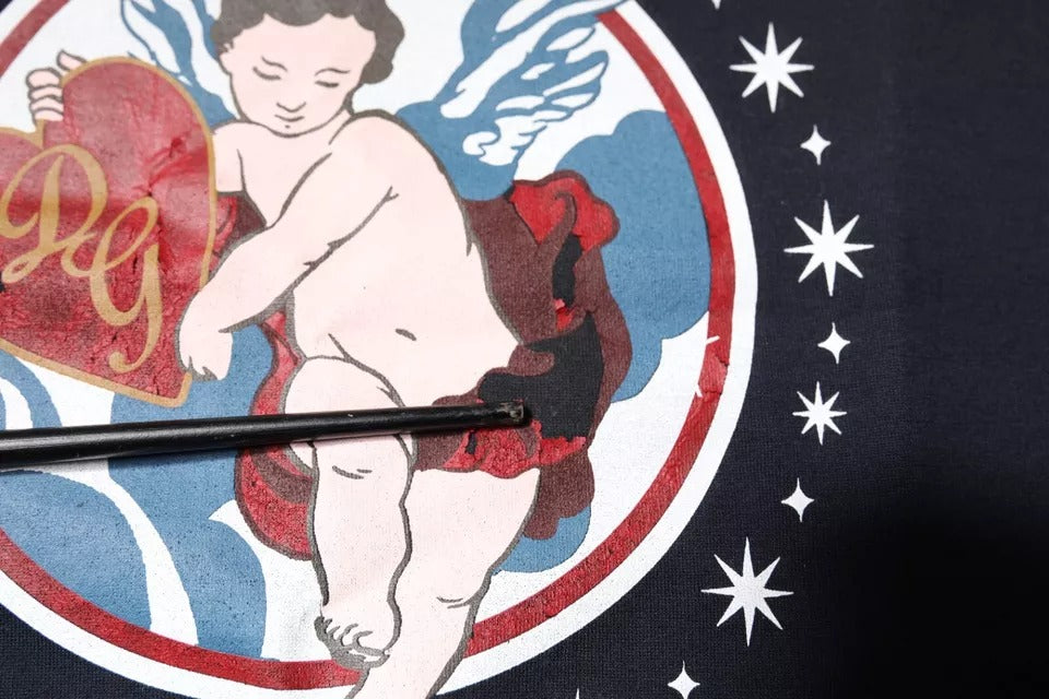 Angelic figure holding heart on circular emblem