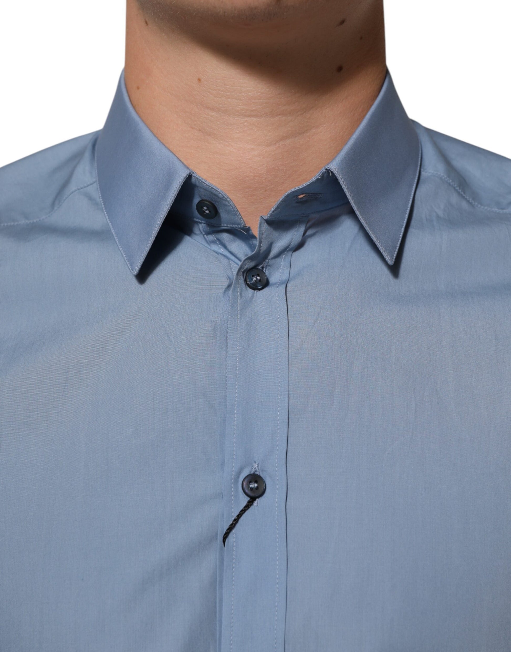 A blue collared dress shirt with gold buttons