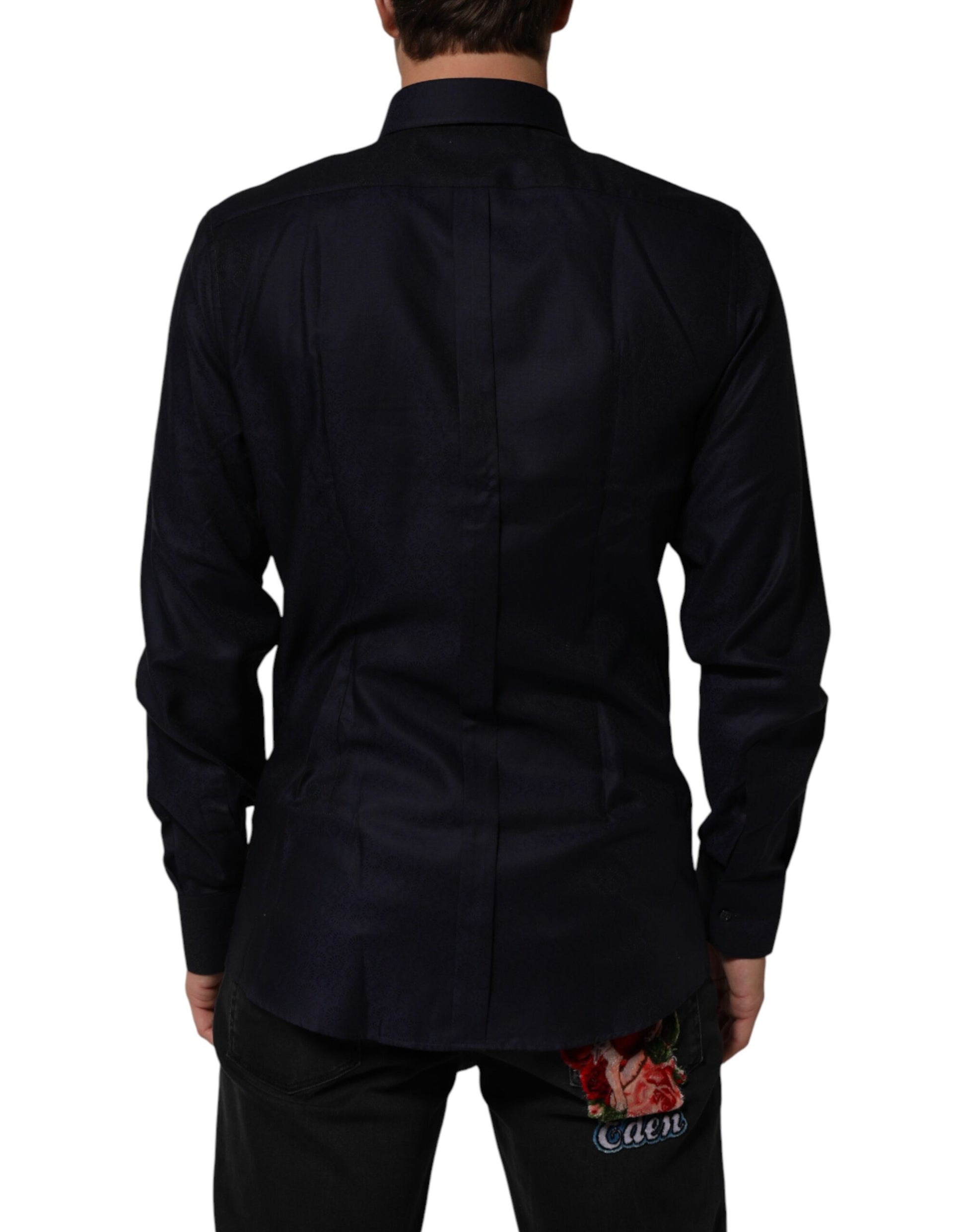 A blue collared long sleeve dress shirt with a gold design