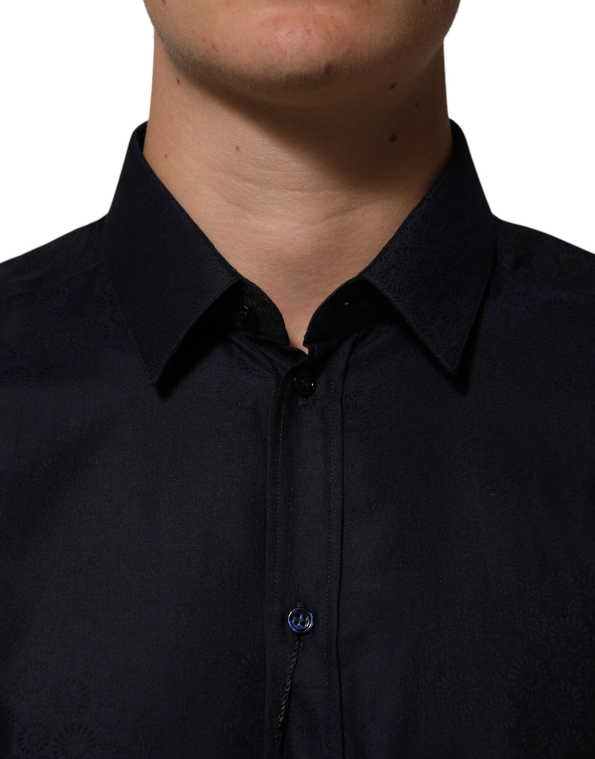 A man wearing a blue collared long sleeve dress shirt