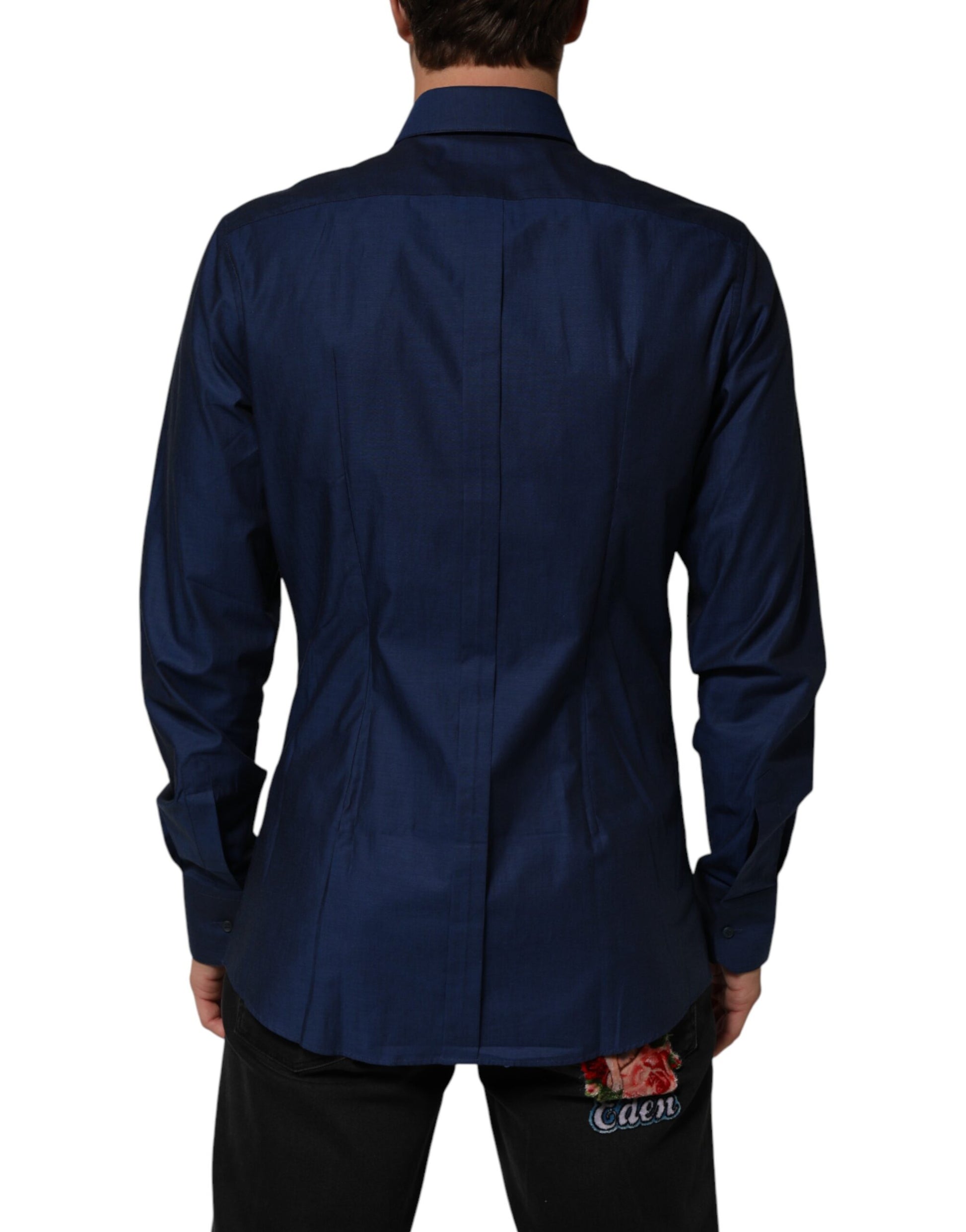 A blue collared dress shirt with a gold design on the front