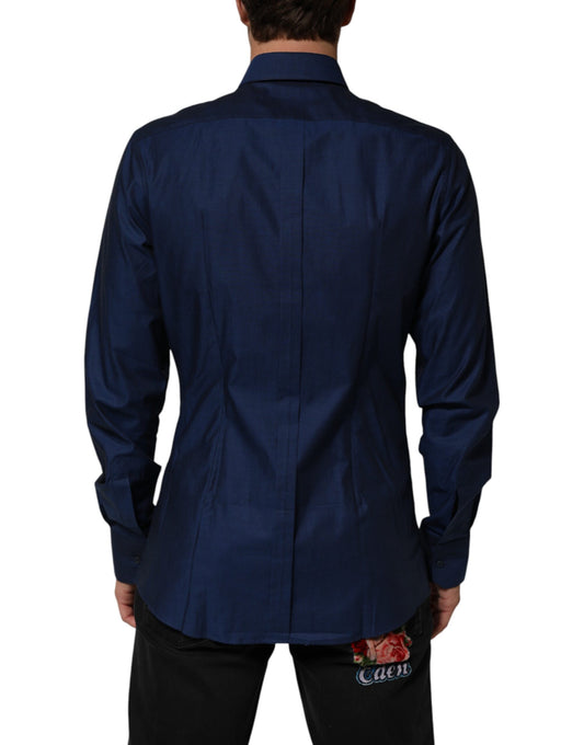 A blue collared dress shirt with a gold design on the front