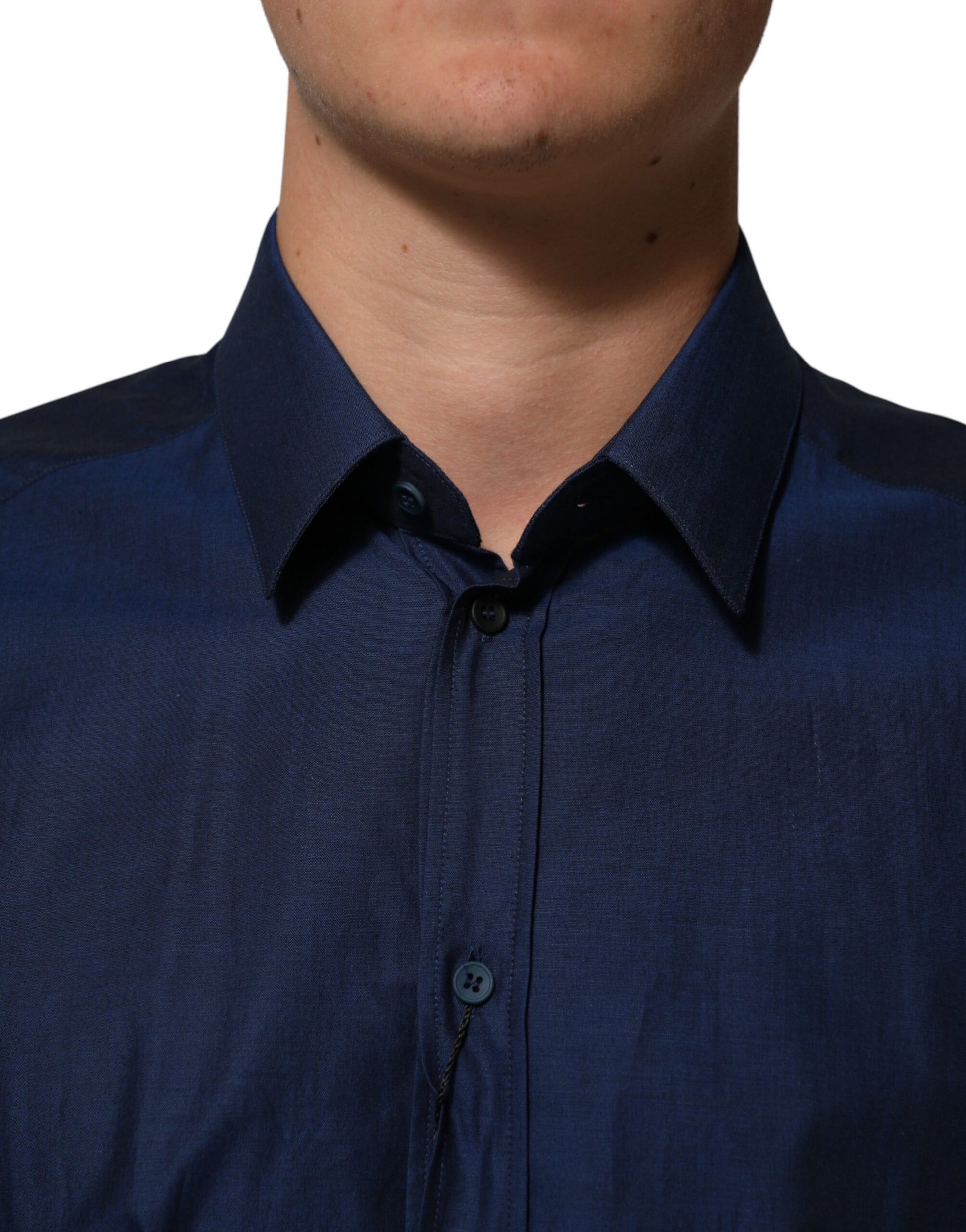A blue cotton collared dress shirt with a gold design on the front