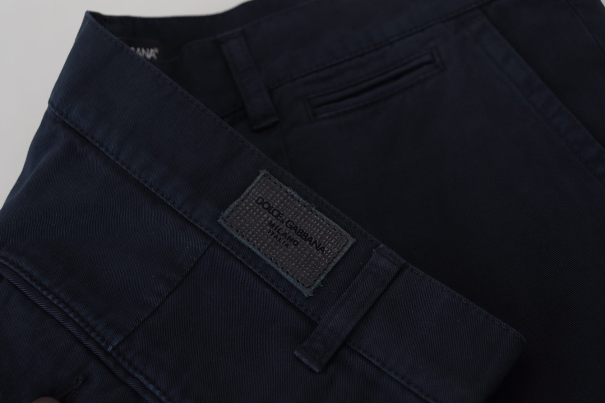 A pair of men's formal trousers with a label on the waistband that reads "D&G". The pants are dark blue in color and appear t