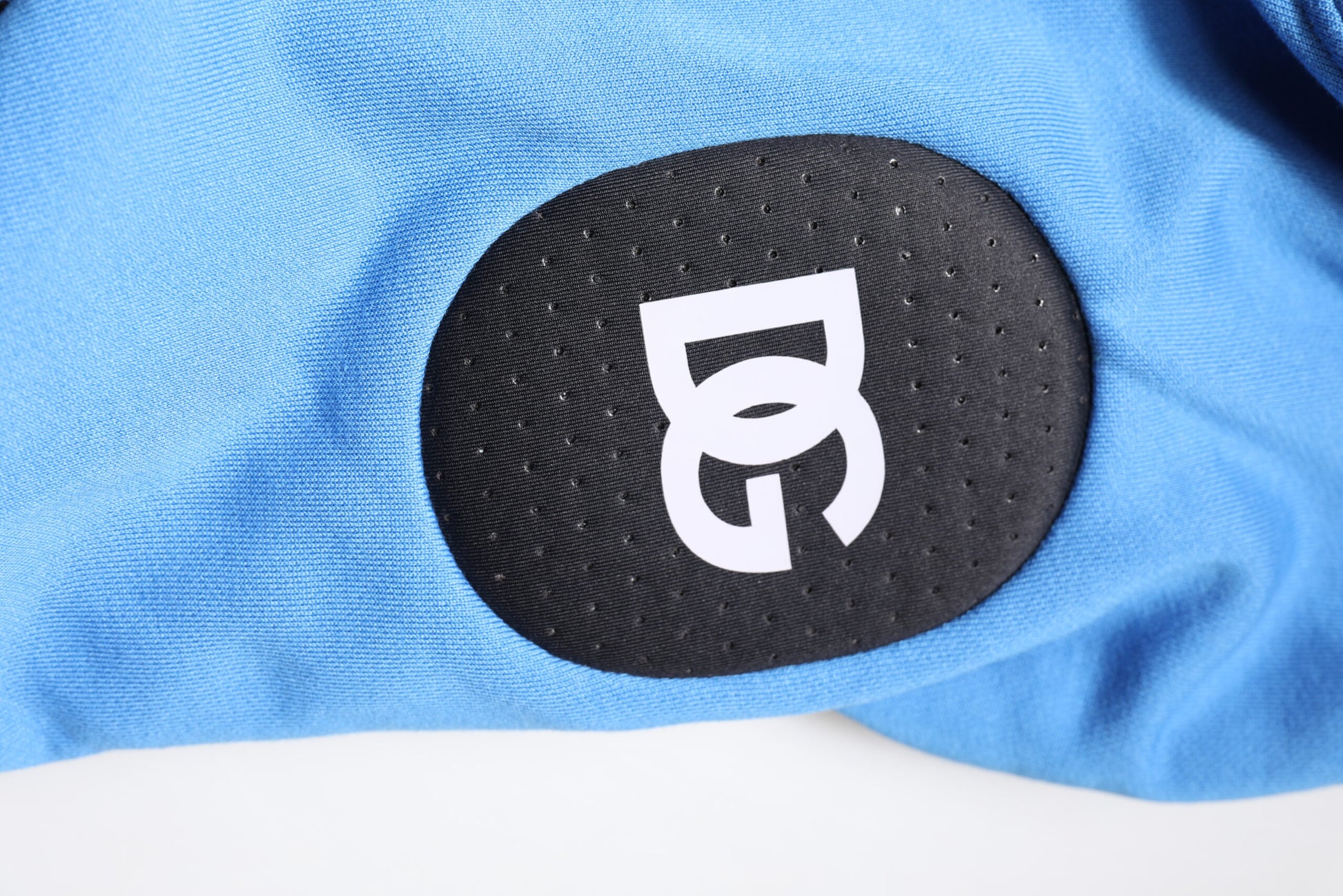 Blue shirt with black logo on sleeve