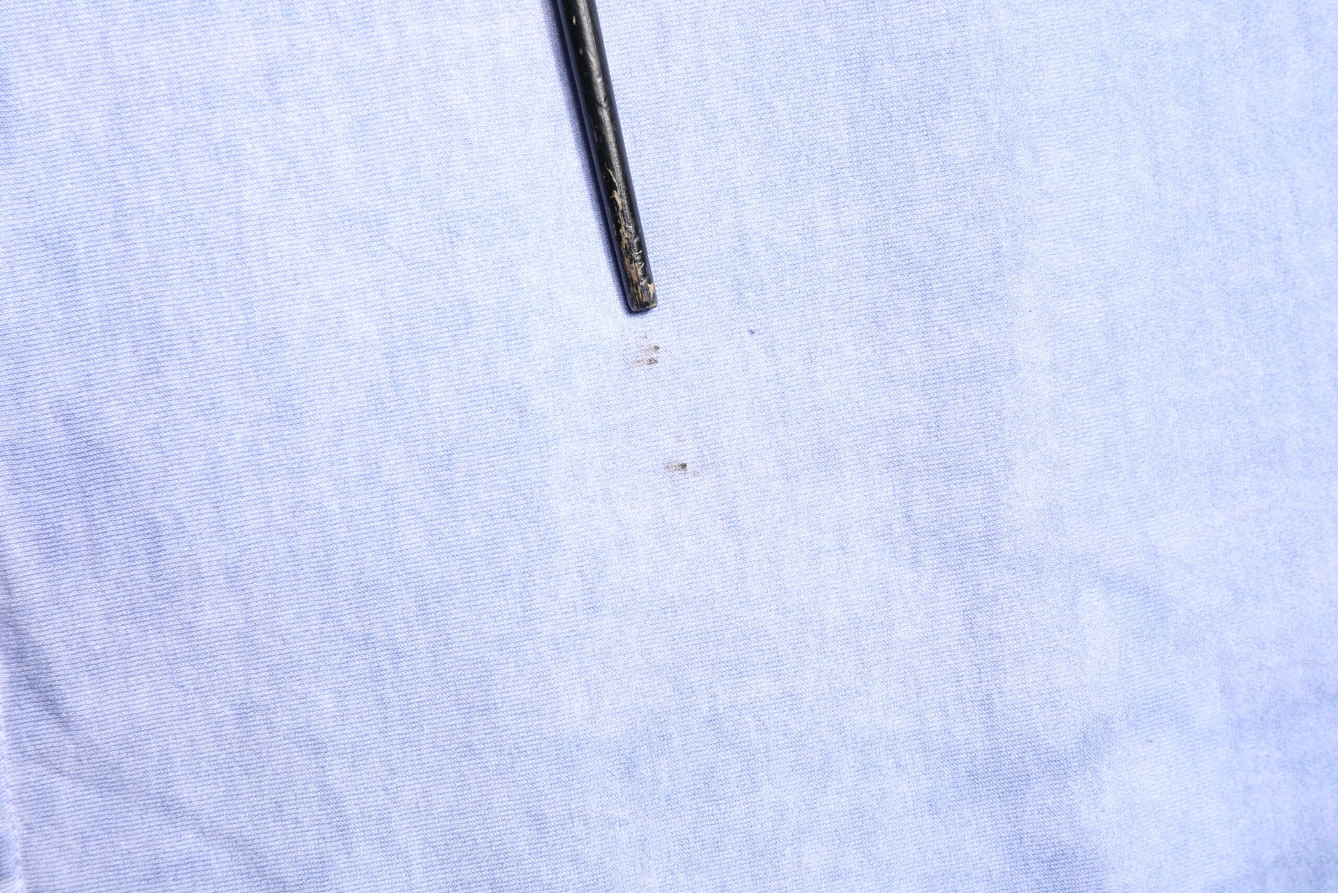 A black sewing needle in a piece of fabric