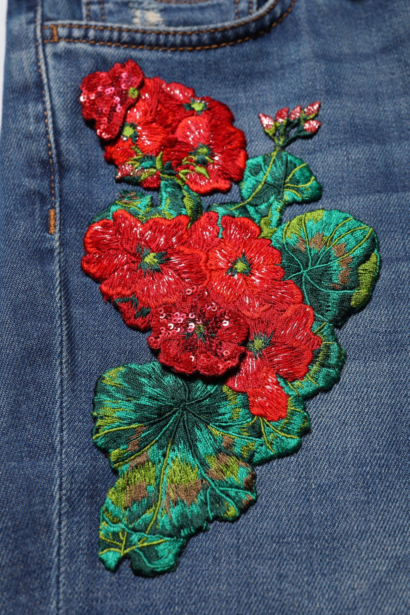 Decorative floral embroidery on denim jeans