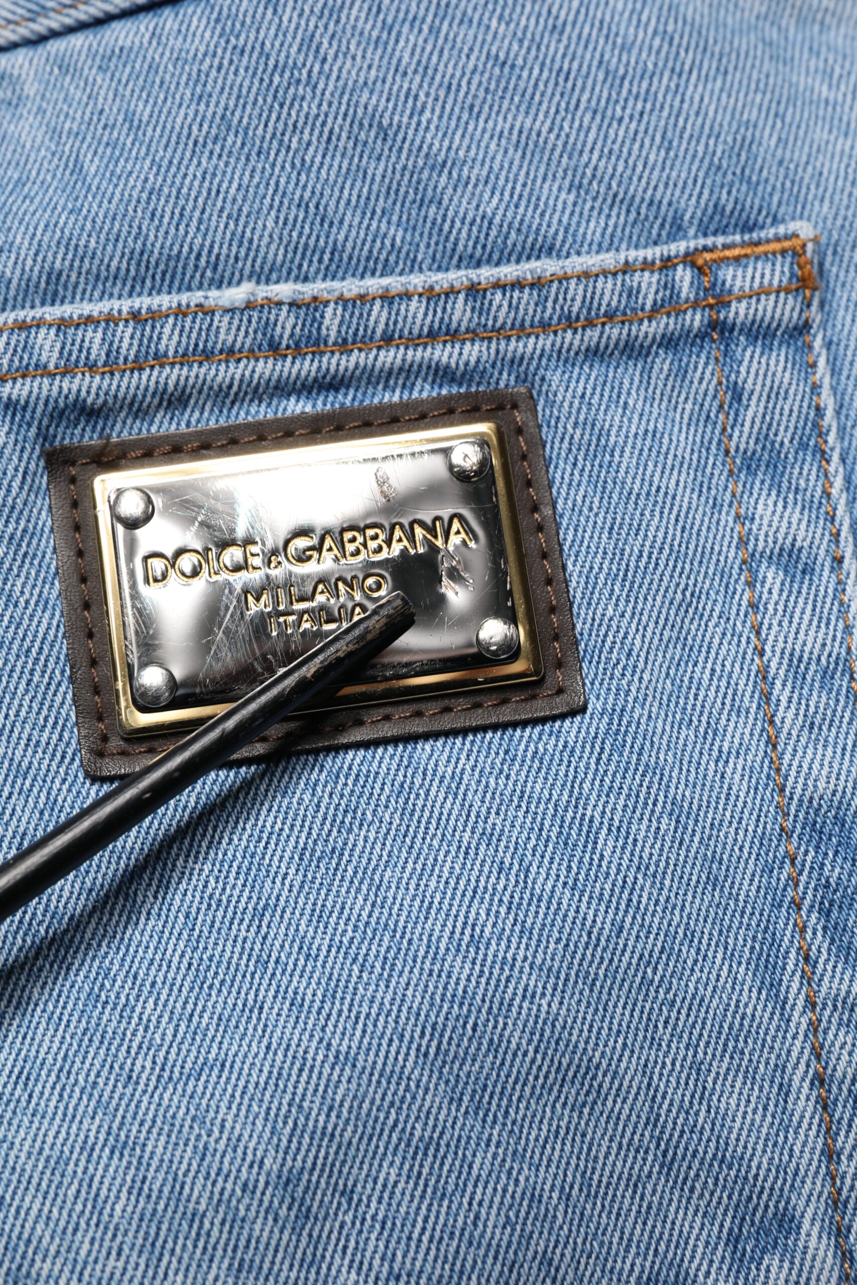 Blue jeans with a gold logo on the back pocket
