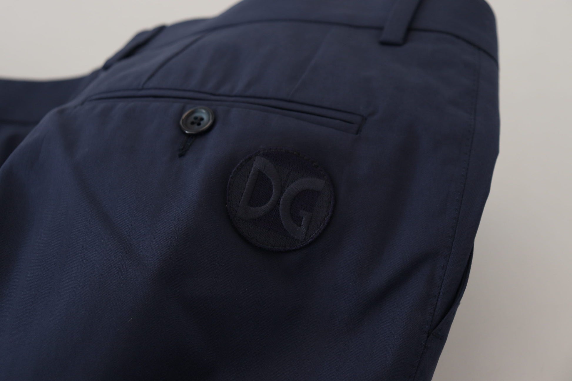 Navy blue pants with a logo on the left side