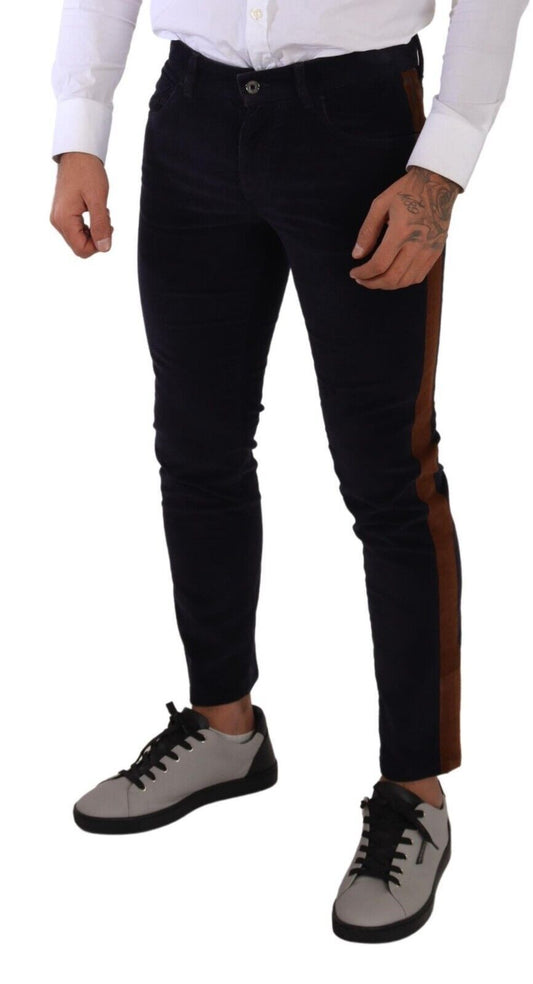 Man wearing black pants with brown stripe down side, white shirt, and grey sneakers