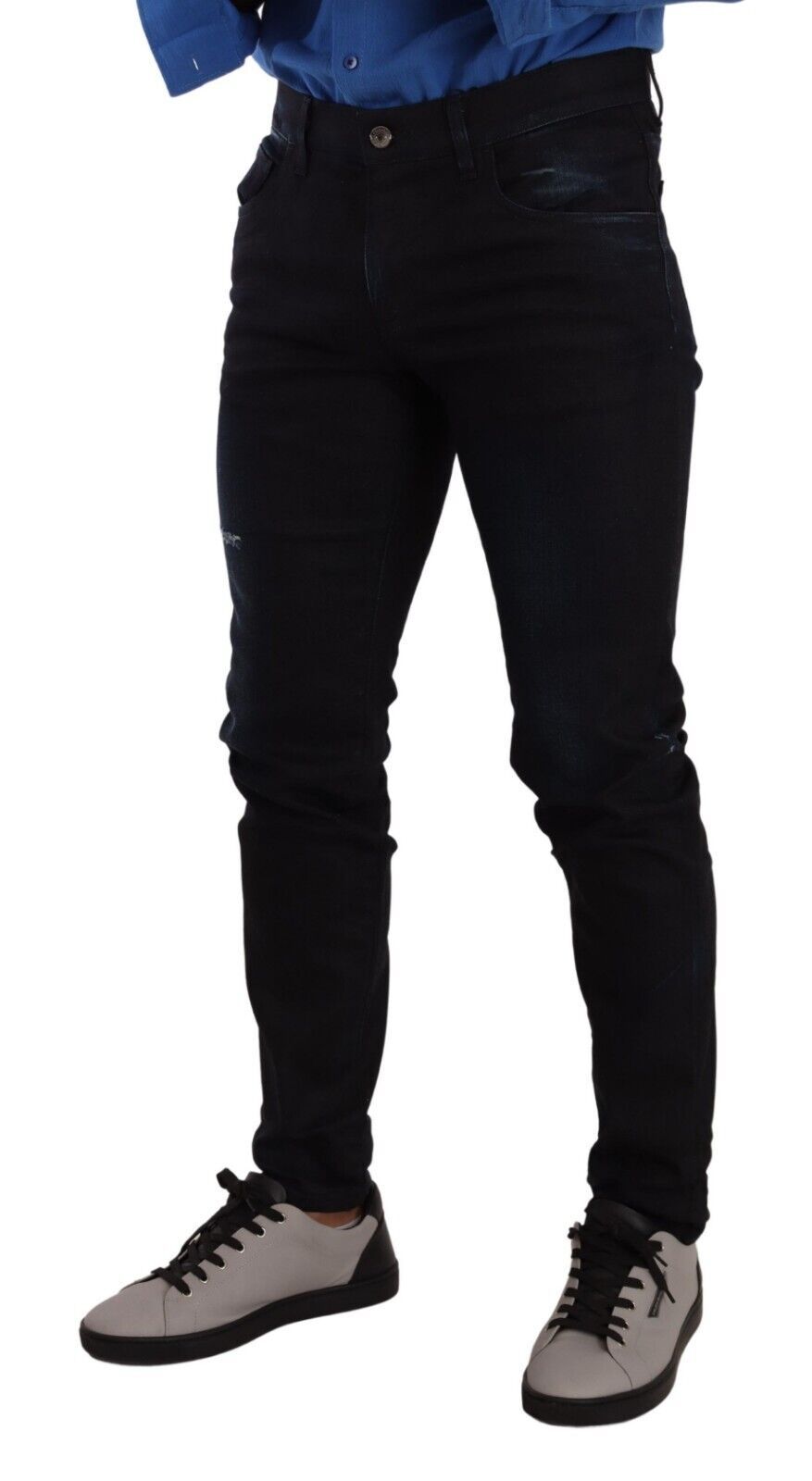 Pair of black jeans on a person standing against white background