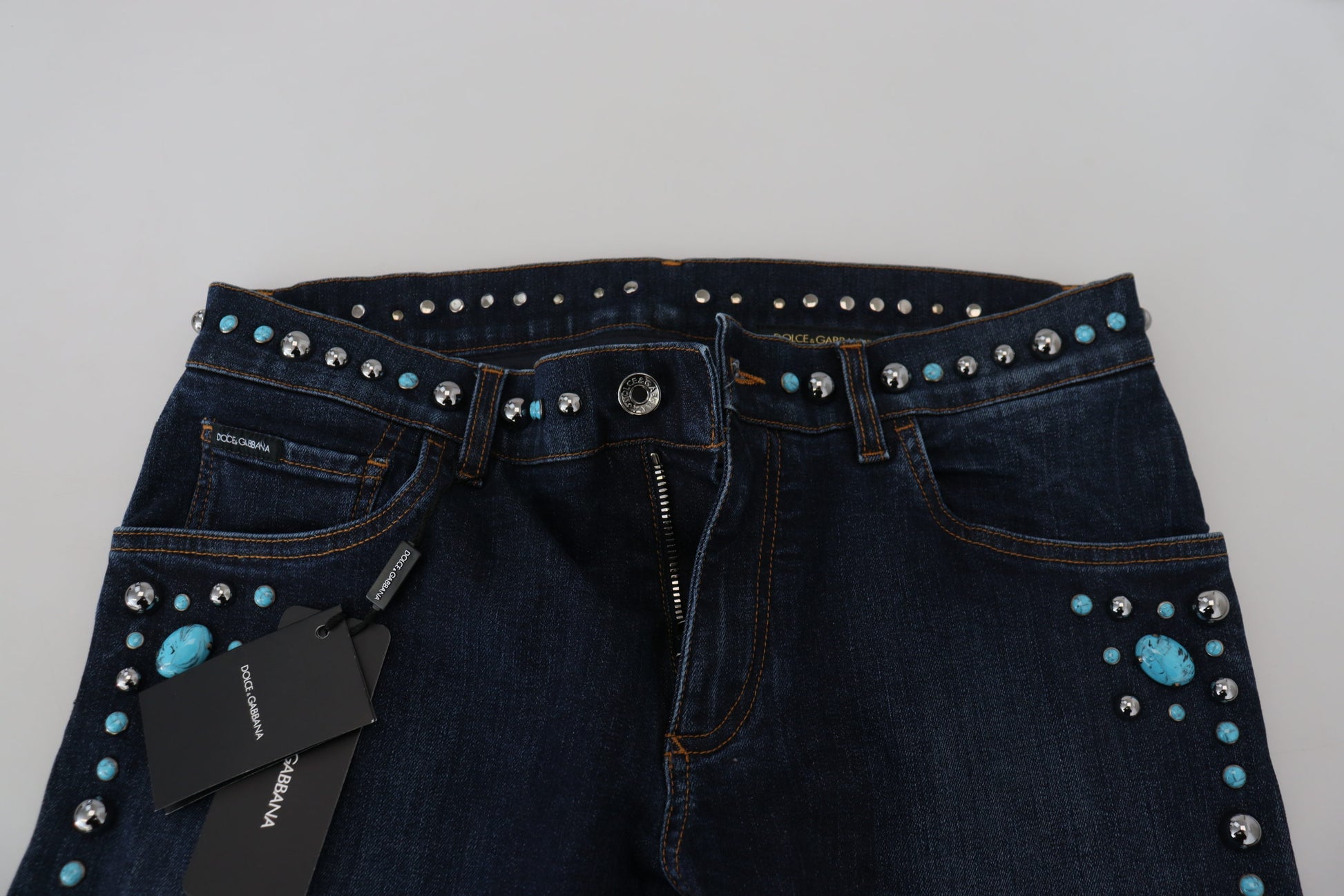 Blue denim jeans with turquoise studs on waistband