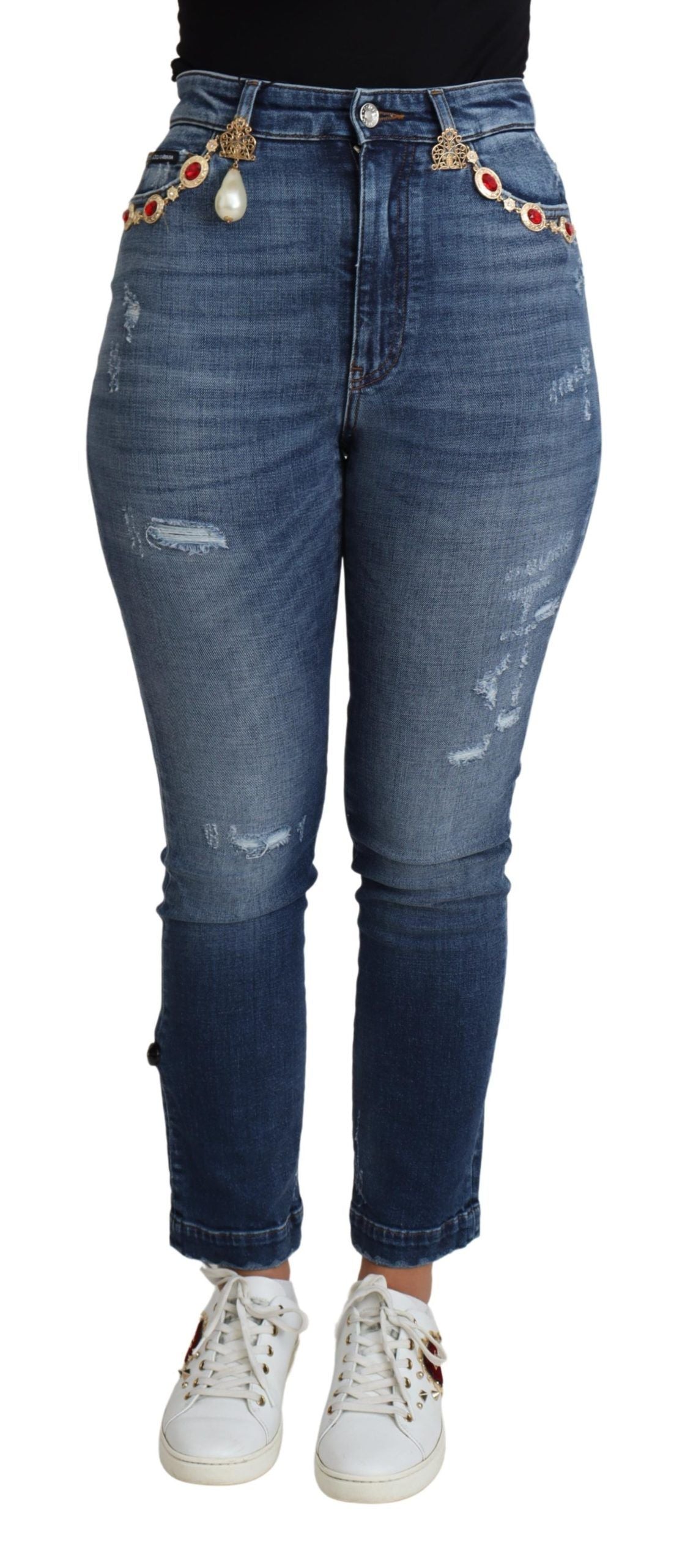 Blue denim jeans with rips and studs on waistband