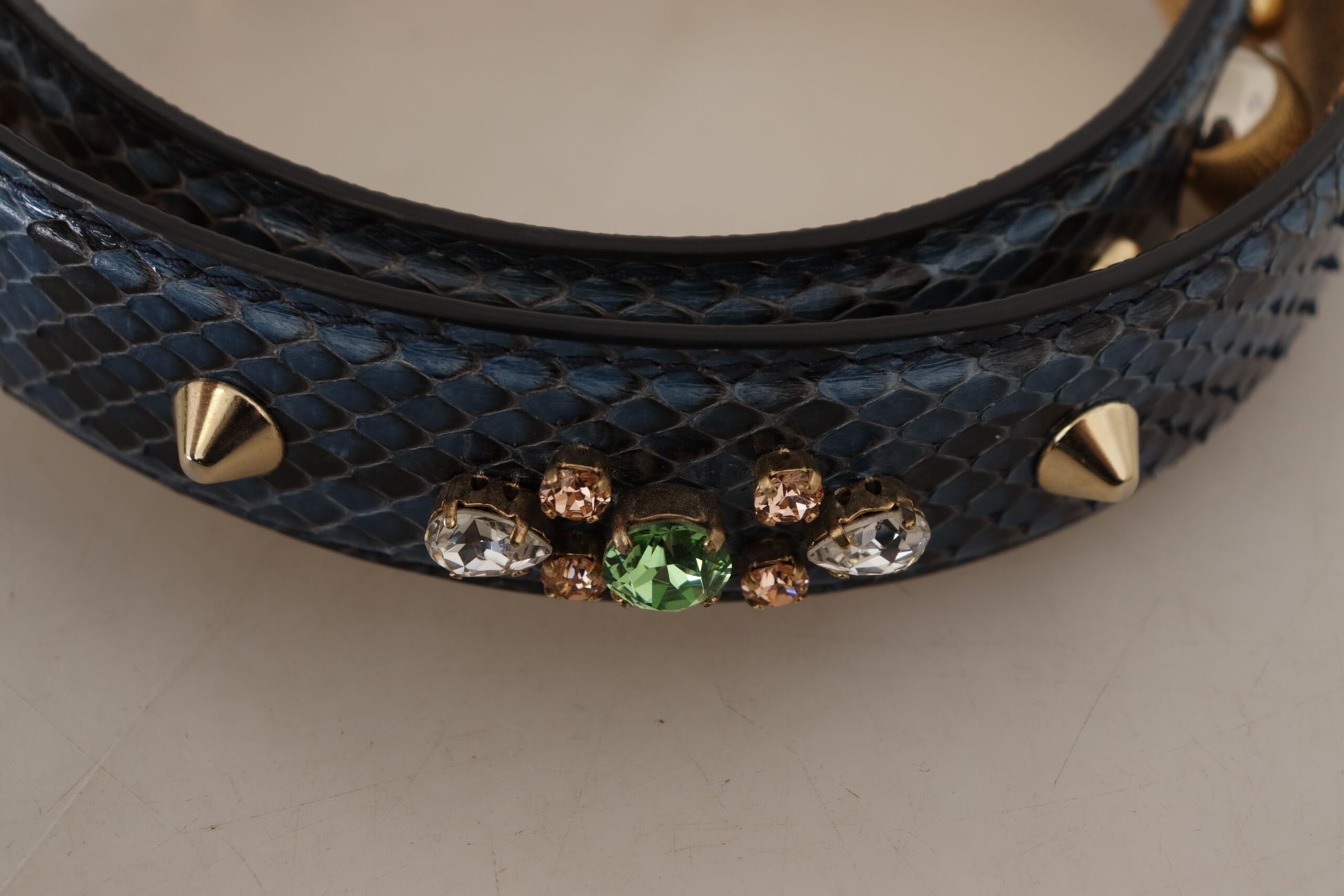 Blue snake skin belt with gold studs and green gemstones