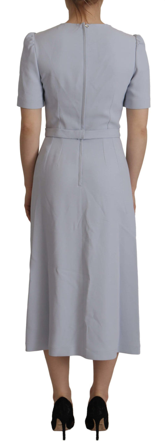 A long sleeve midi dress with floral applique design on a blue background