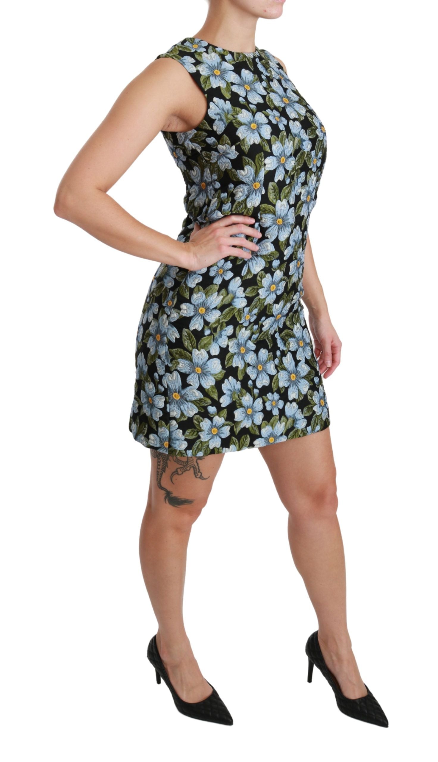 A woman wearing a blue floral brocade dress with short sleeves and a flared skirt